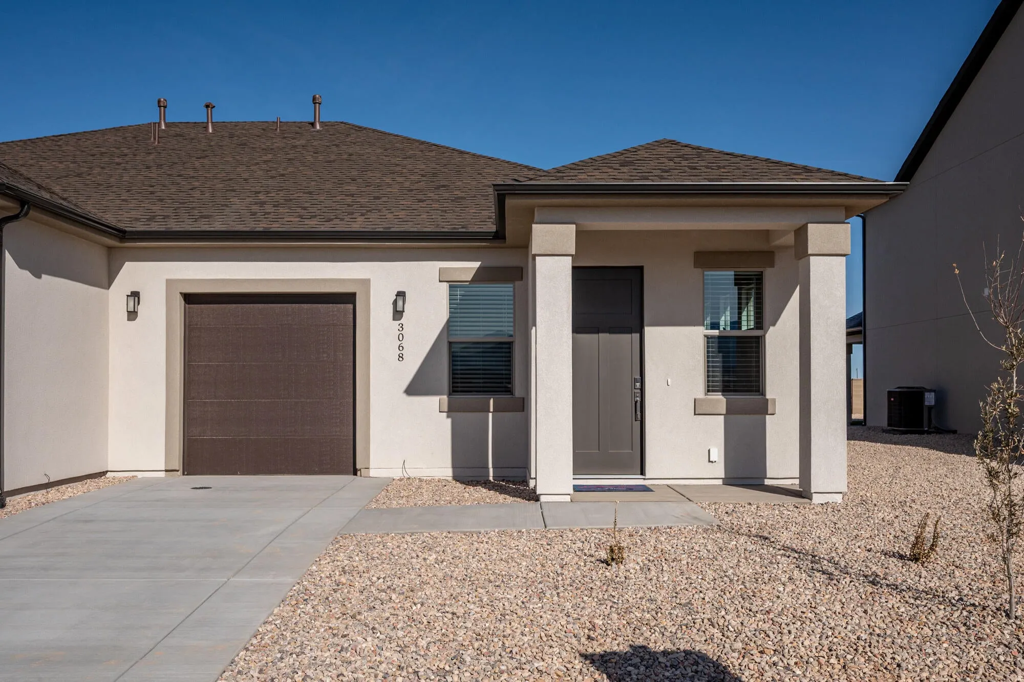 View of front of home featuring an attached garage, stucco siding, and a porch