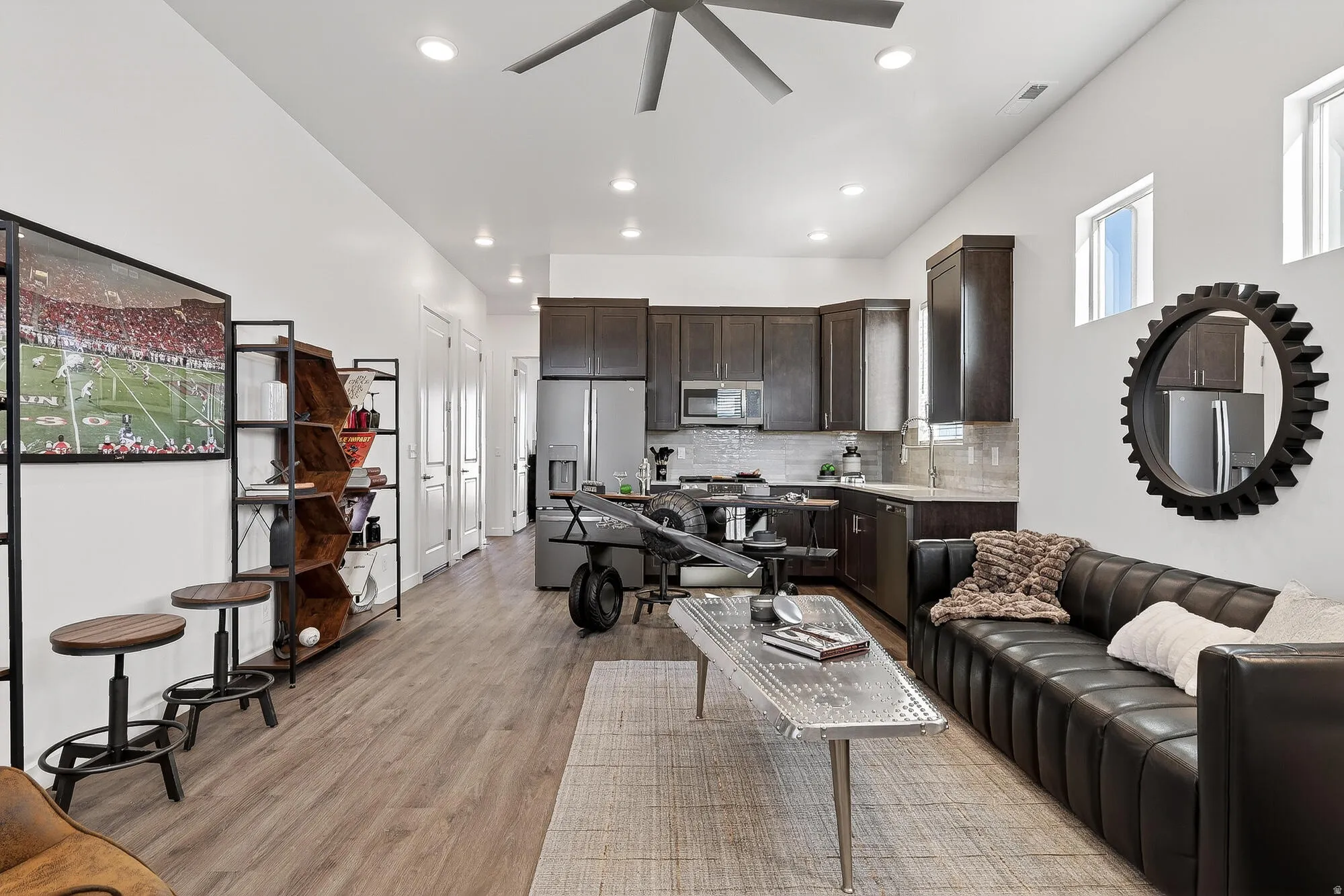 Living room with a ceiling fan, light wood-style floors, and recessed lighting