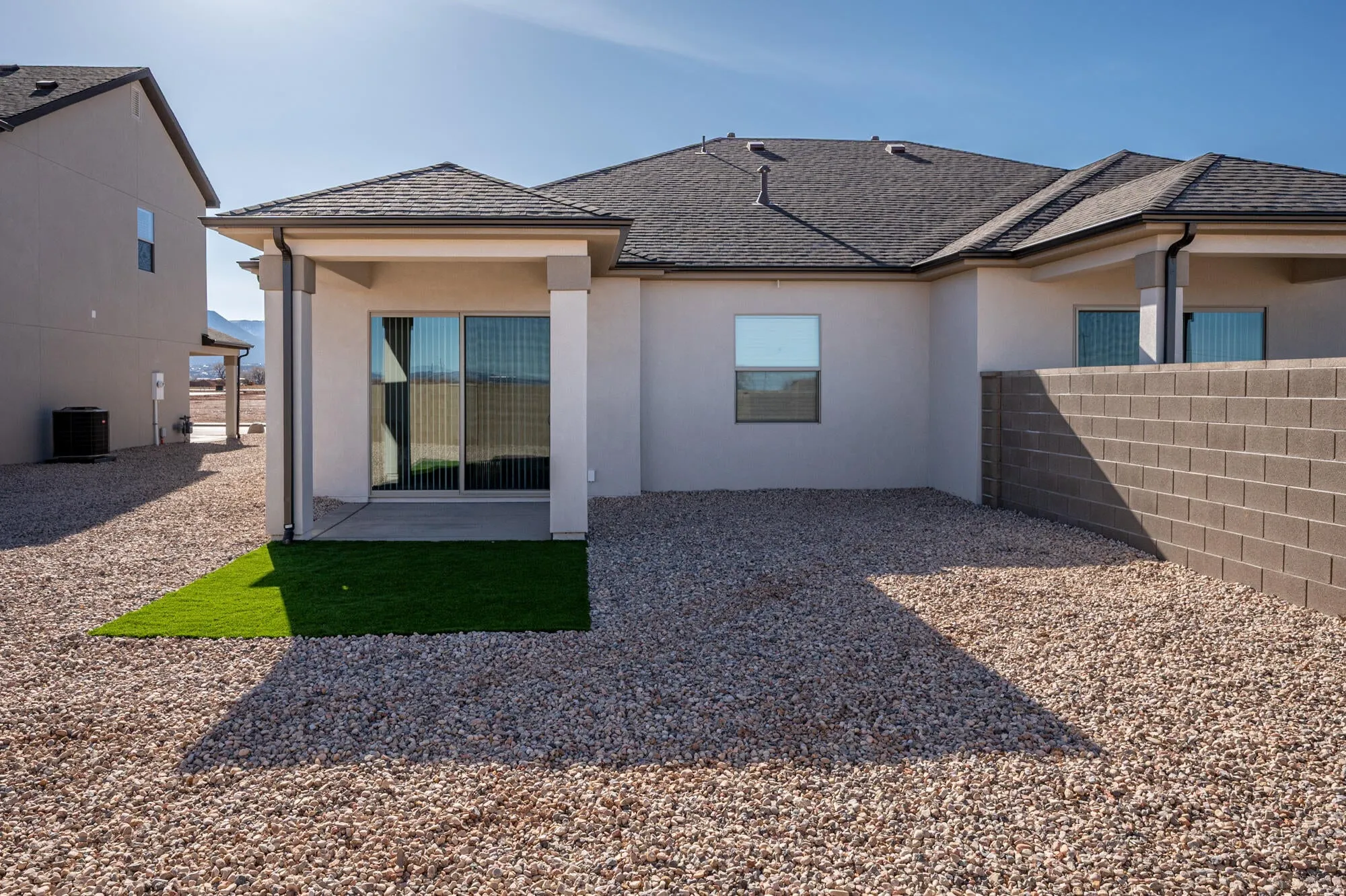 Rear view of house with stucco siding and a patio