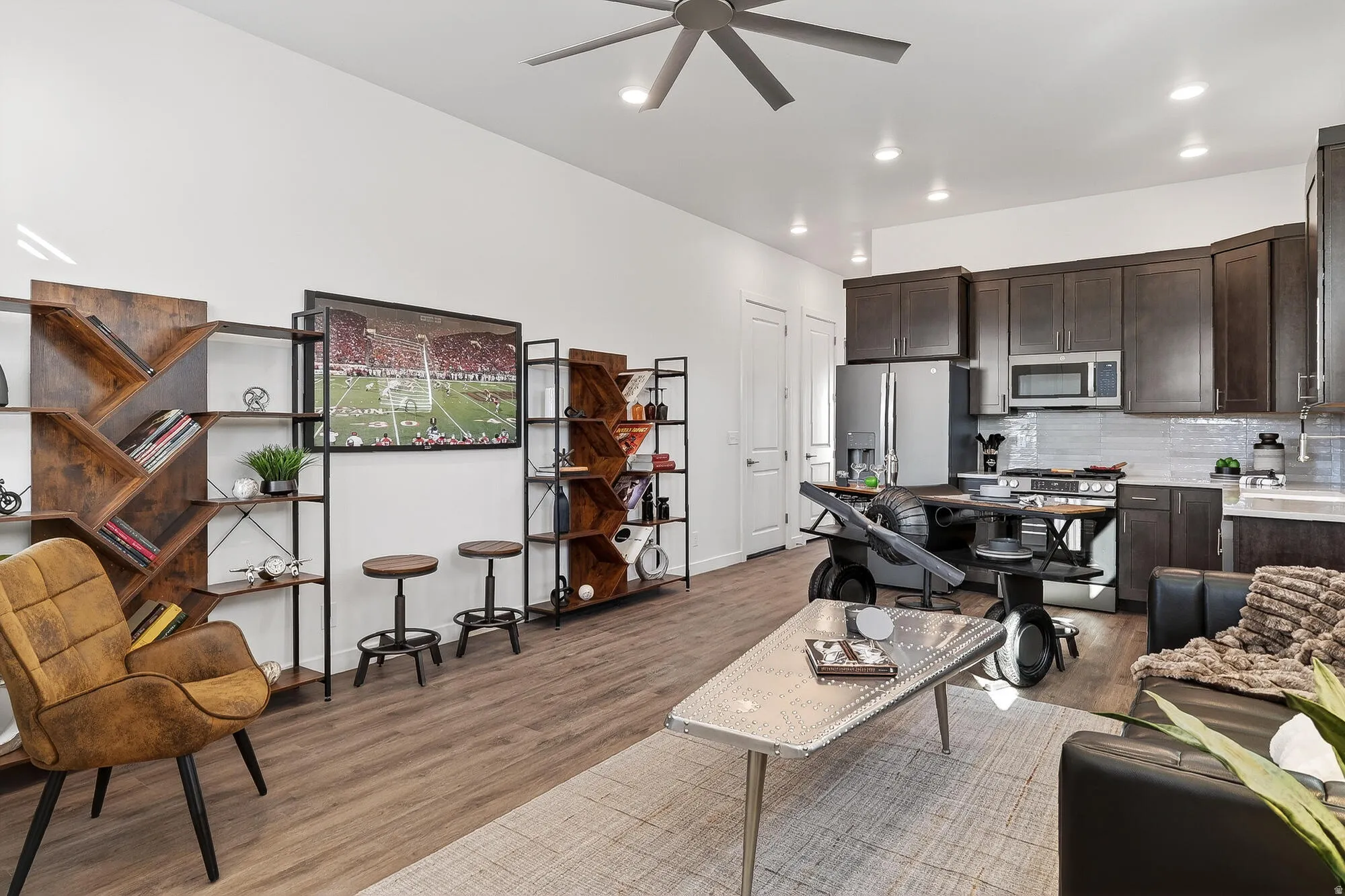 Living room with ceiling fan, light wood-style floors, and recessed lighting