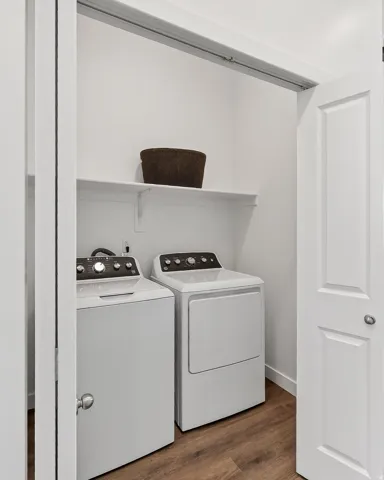 Laundry area with dark wood-type flooring and washer and clothes dryer