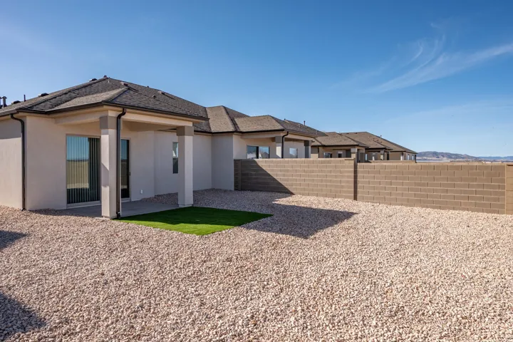 Back of property with stucco siding and a patio