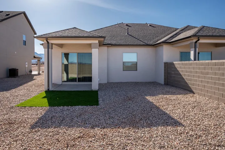 Rear view of house with stucco siding and a patio