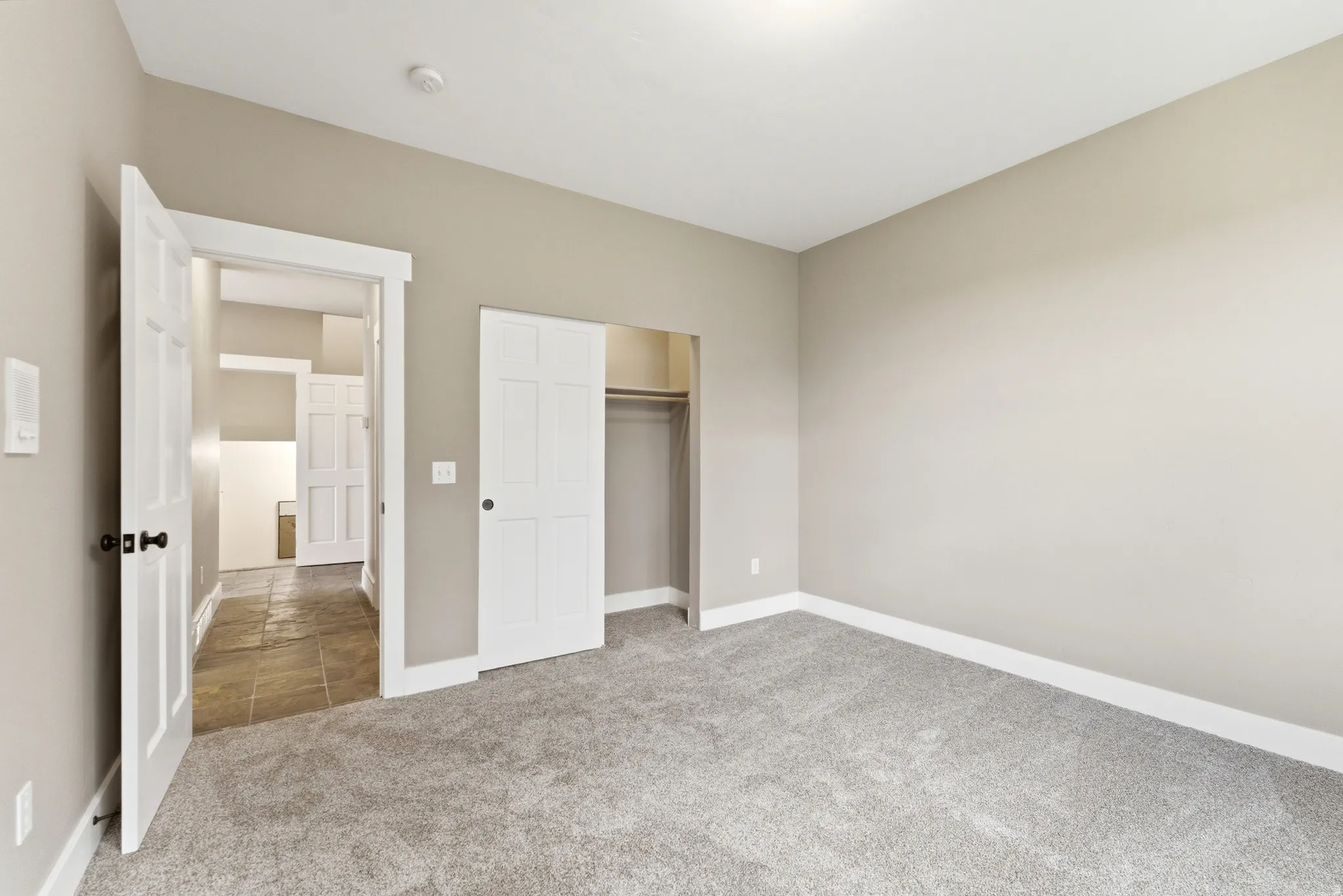 Unfurnished bedroom with light colored carpet and a closet