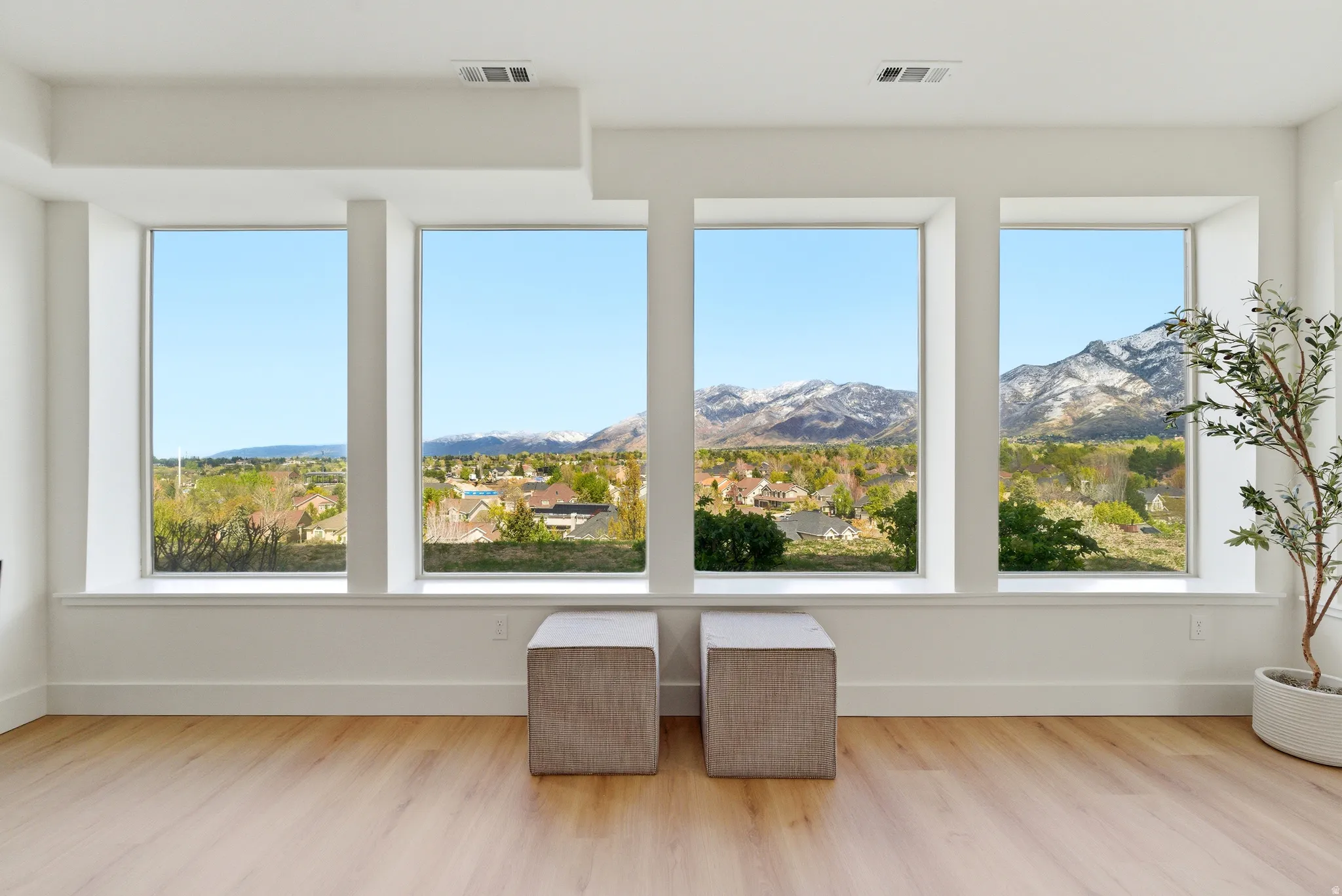 Sunroom with wood finished floors, a mountain view, and a residential view
