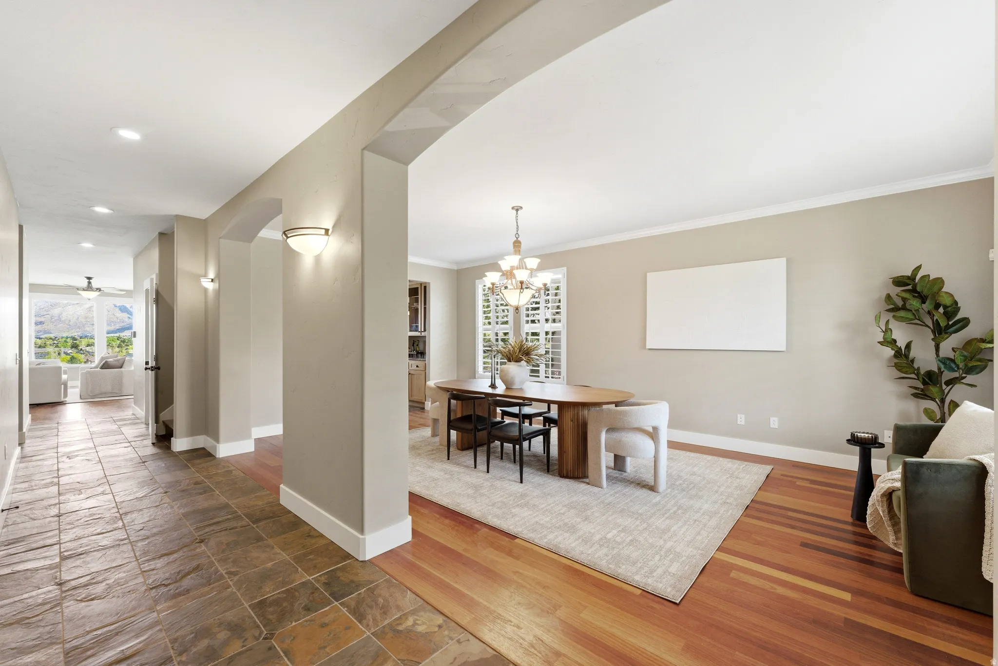 Large formal dining area with wood finished floors, a chandelier, and ornamental molding