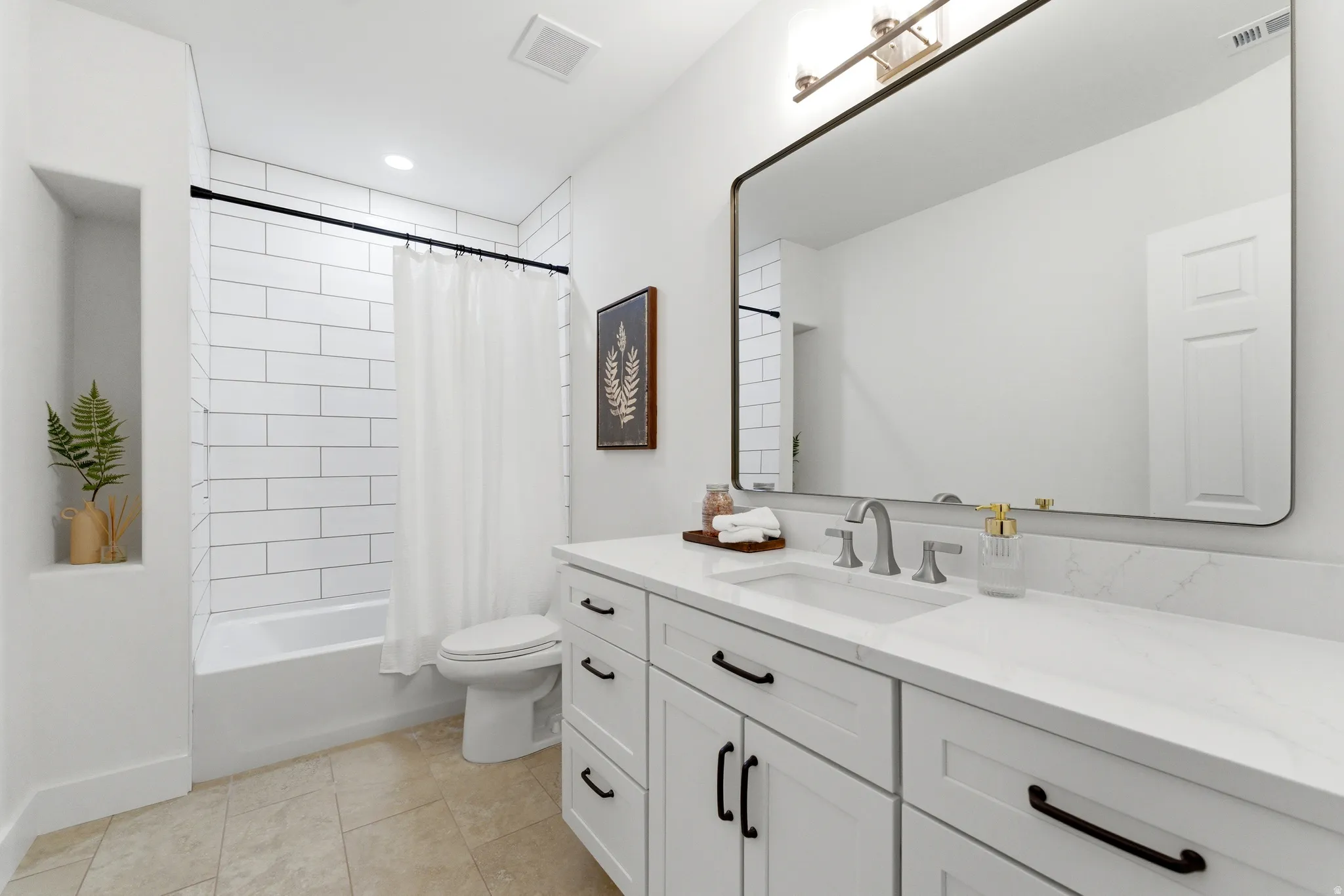 Full bathroom with vanity, shower / tub combo, and gorgeous new tile on floor and shower. New quartz countertops and cabinets. All bathrooms have new toilets , countertops and faucets.