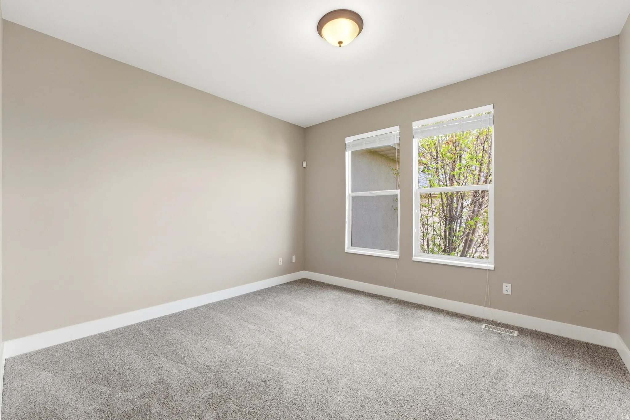 Empty room featuring light carpet and baseboards