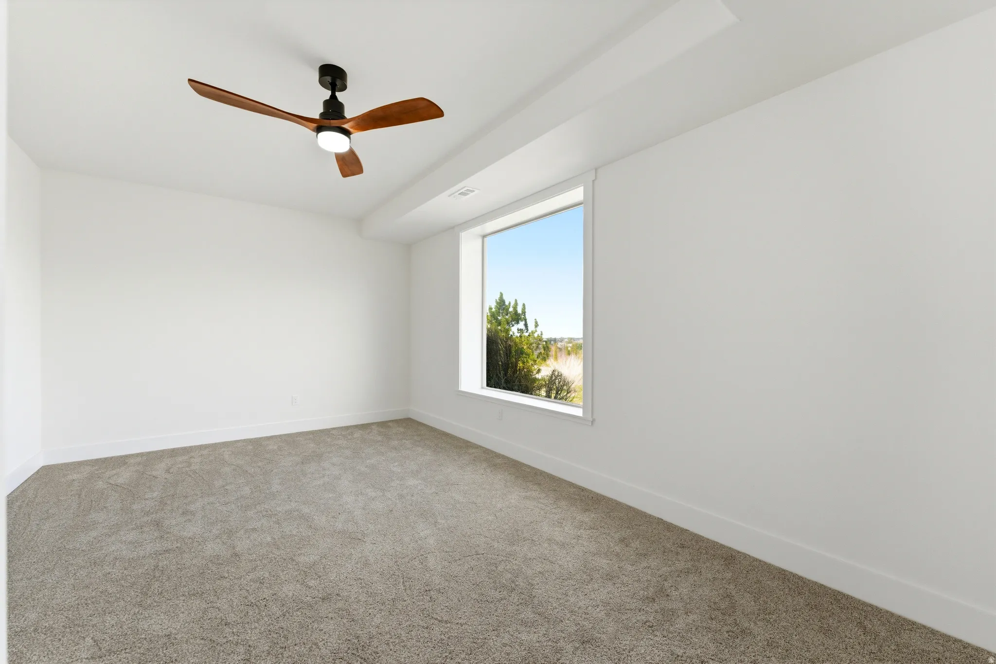 Spare room featuring carpet floors and ceiling fan