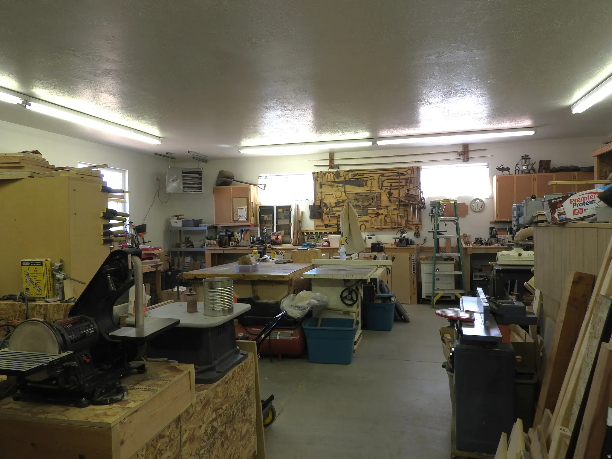 Garage featuring a heating unit and a workshop area