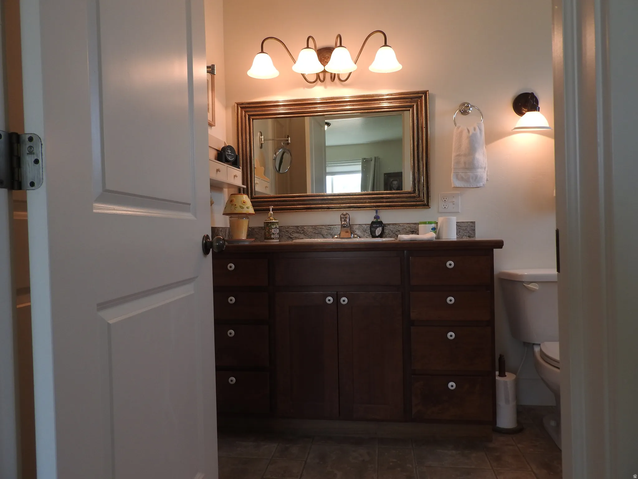 Bathroom featuring vanity and dark tile patterned flooring