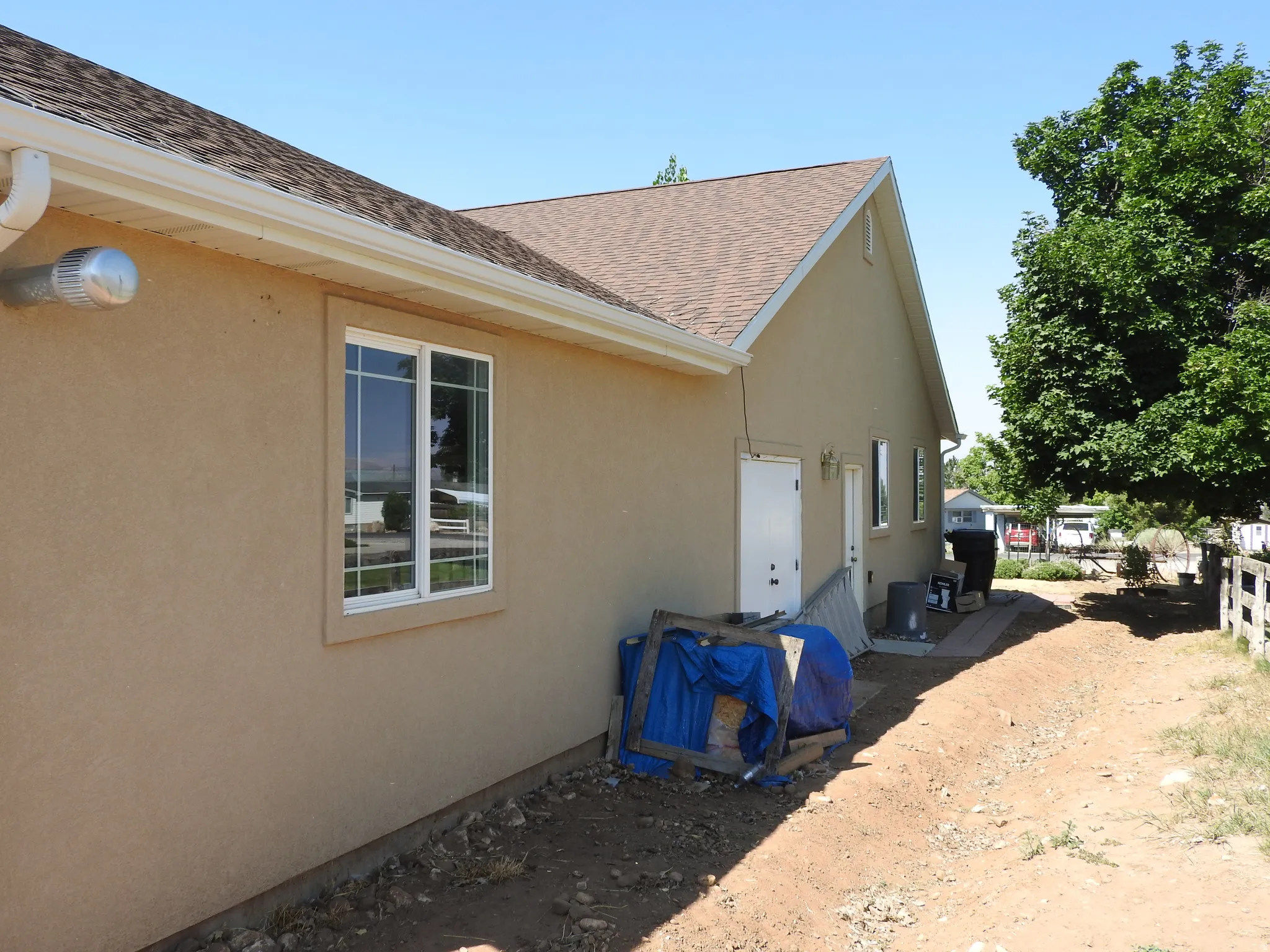 View of property exterior with roof with shingles and stucco siding