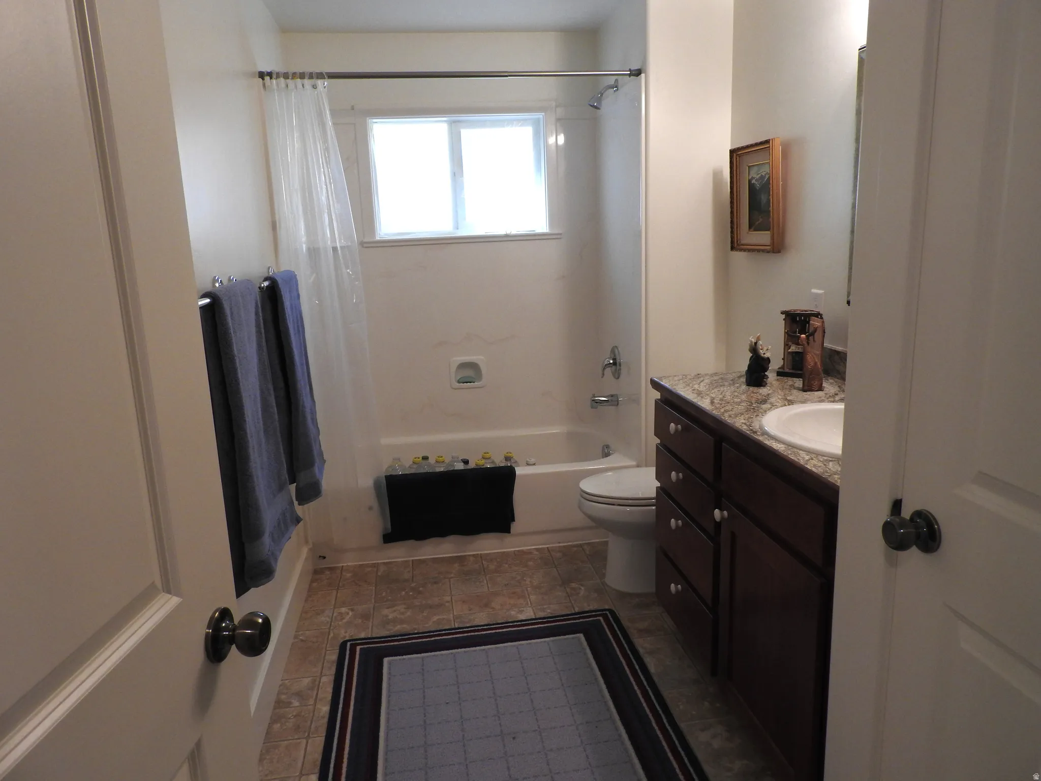 Bathroom featuring vanity and shower / bathtub combination with curtain