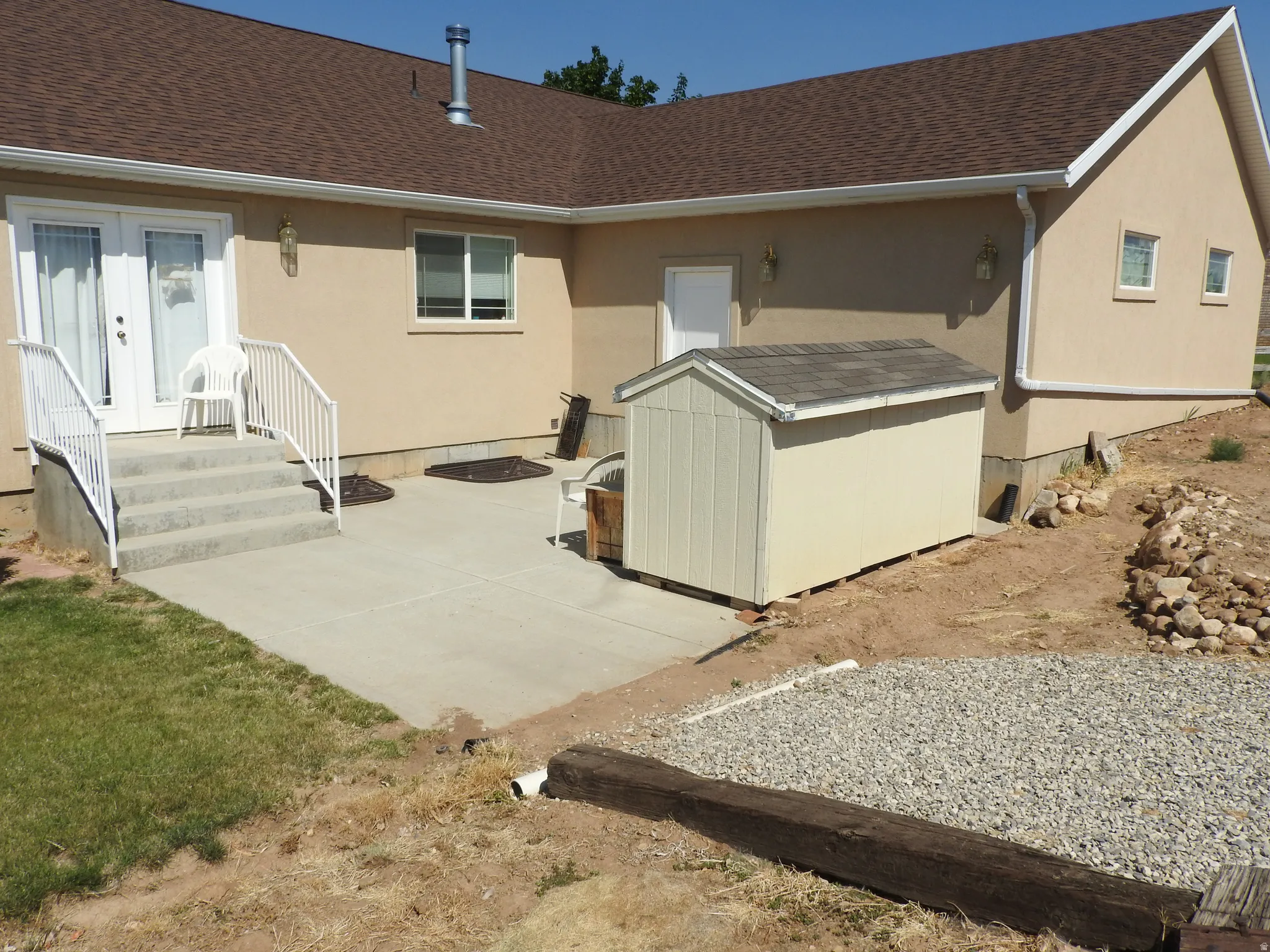 Rear view of house with french doors, stucco siding, and roof with shingles