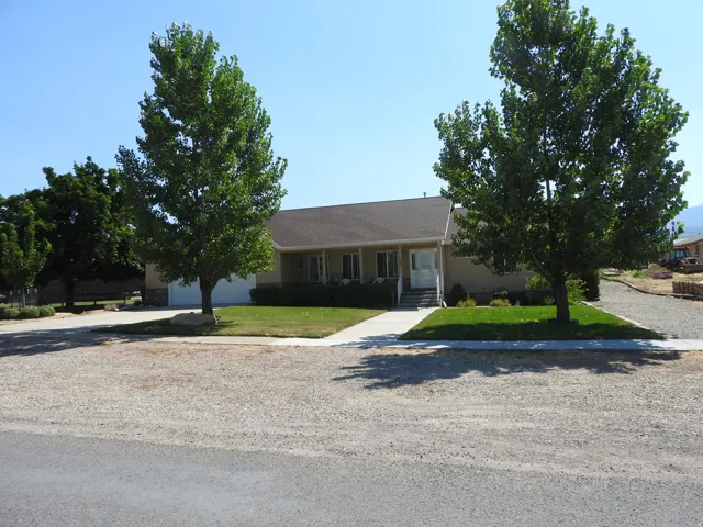Ranch-style home featuring a porch, a front lawn, driveway, and an attached garage