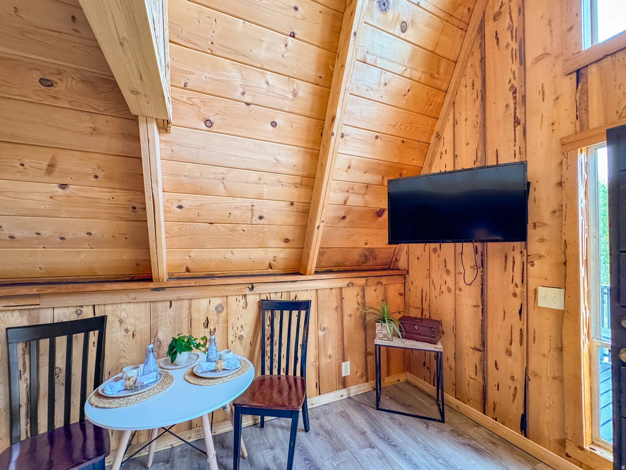 Sitting room featuring wood walls, wood finished floors, and a vaulted wooden ceiling