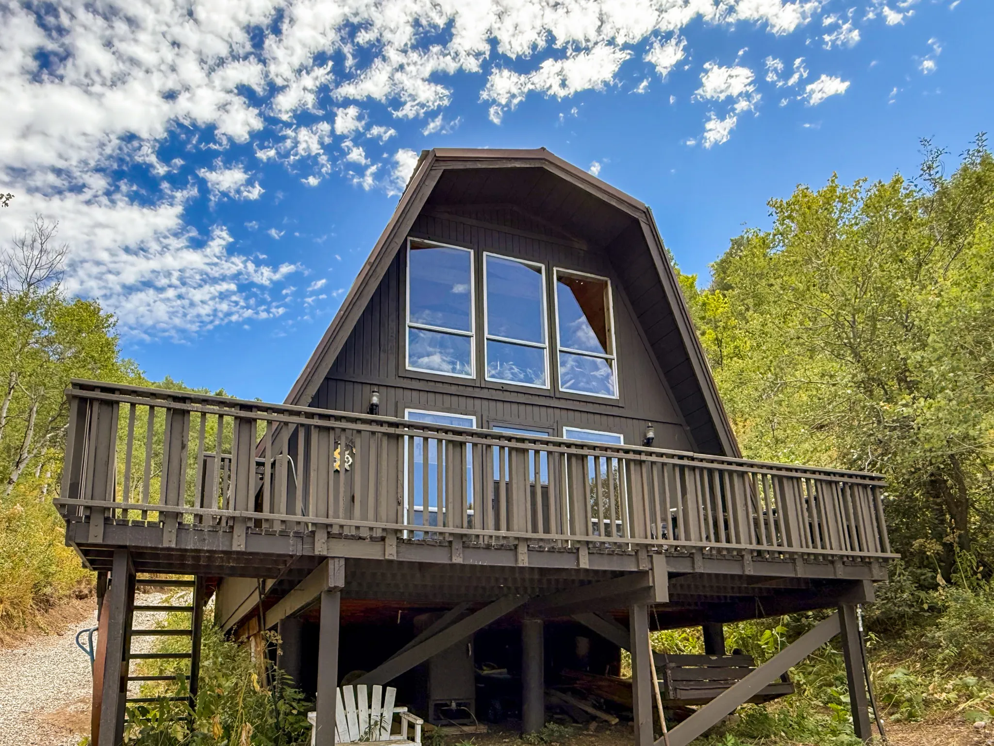 Back of house with a wooden deck and stairs