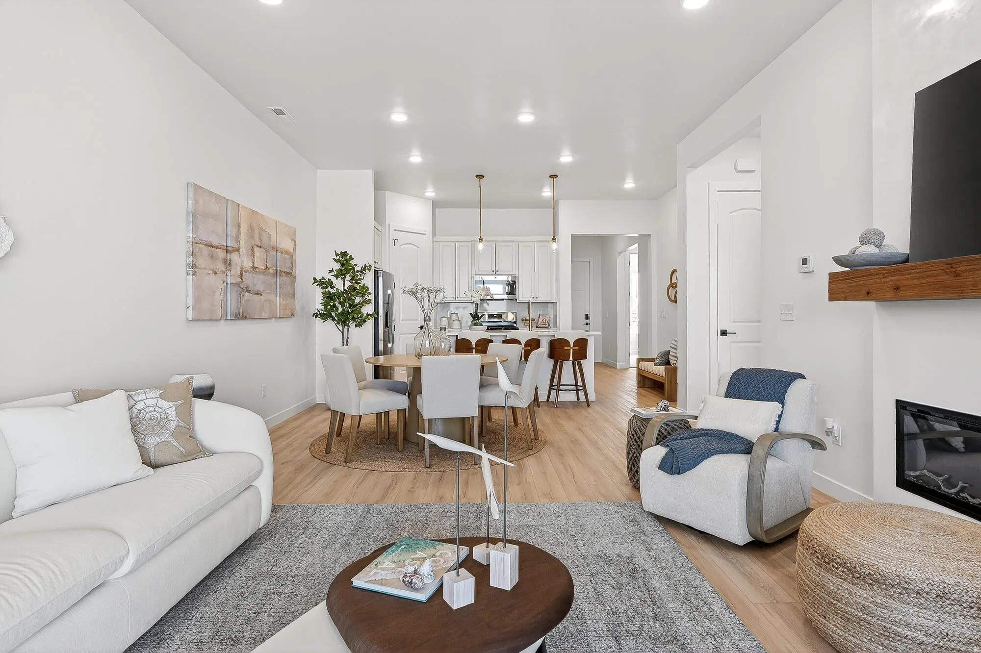 Living area with a glass covered fireplace, light wood-style floors, and recessed lighting