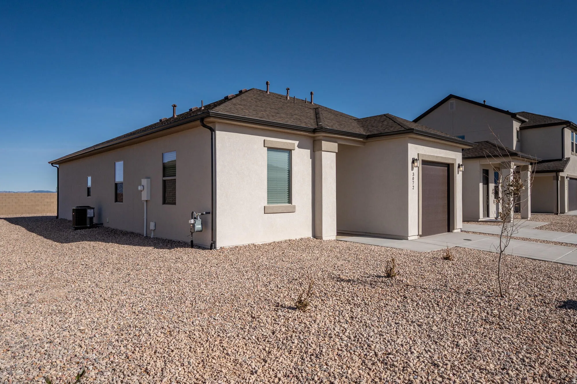 View of side of property with stucco siding, an attached garage, and driveway