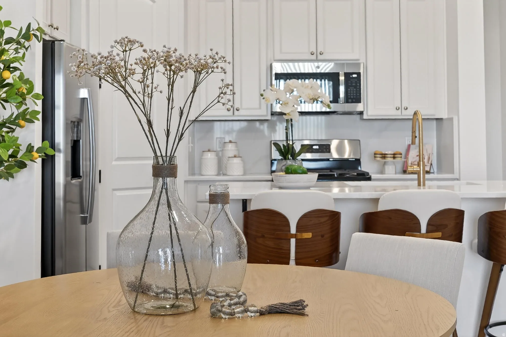 Kitchen with stainless steel appliances, a kitchen breakfast bar, white cabinetry, and light stone counters