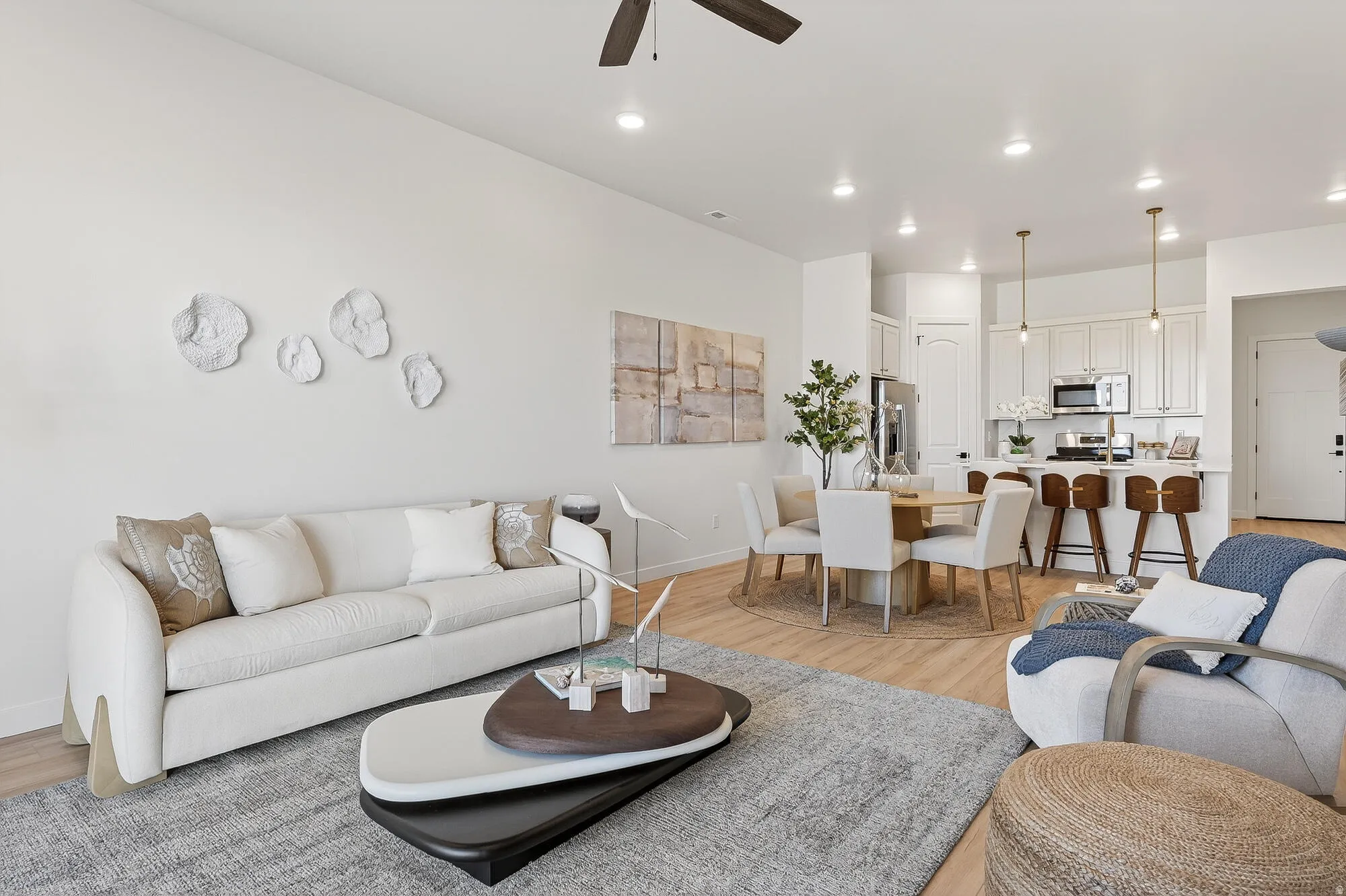 Living room with light wood finished floors, ceiling fan, and recessed lighting
