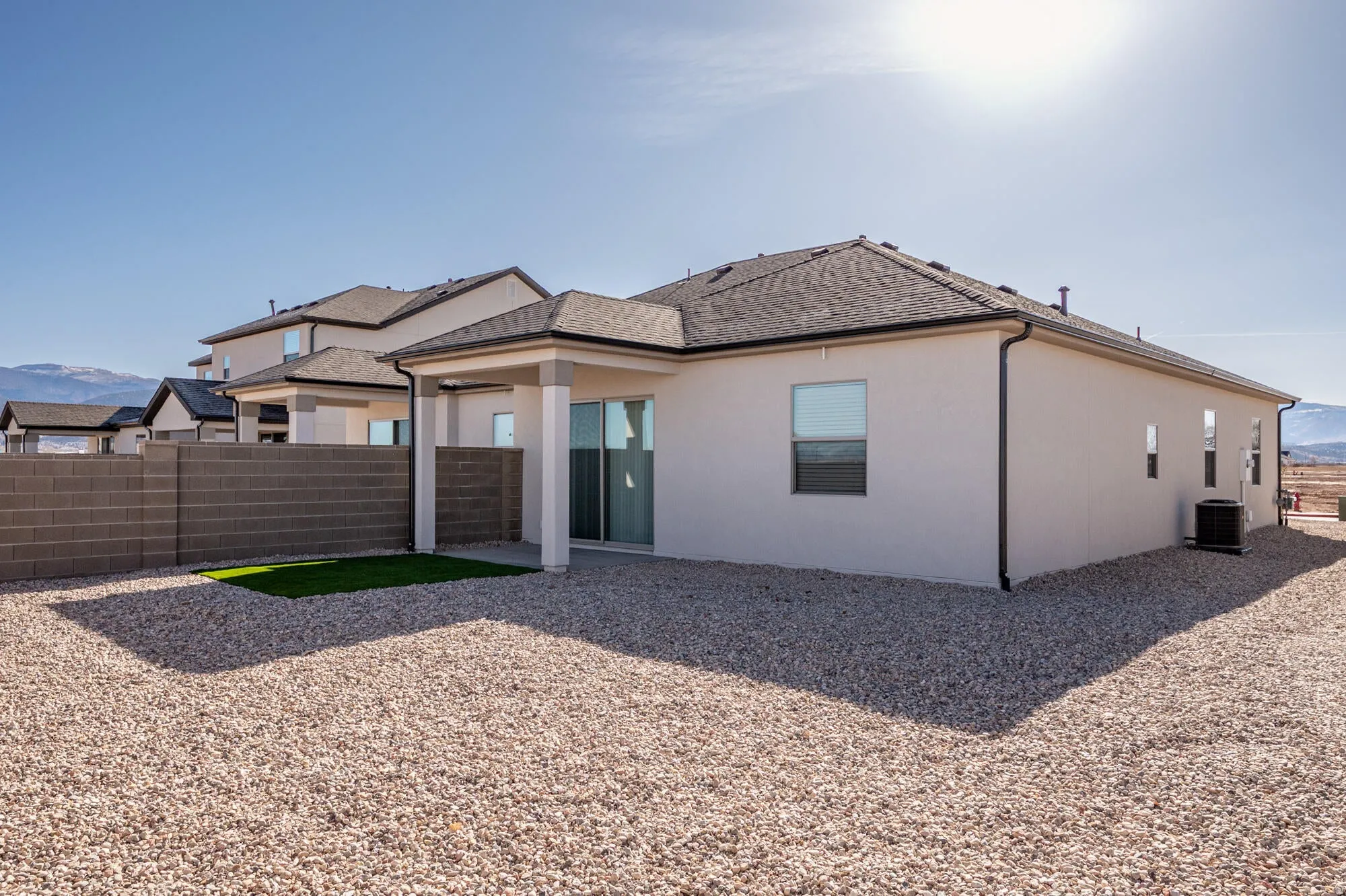 Back of property with a patio, stucco siding, a mountain view, and a shingled roof