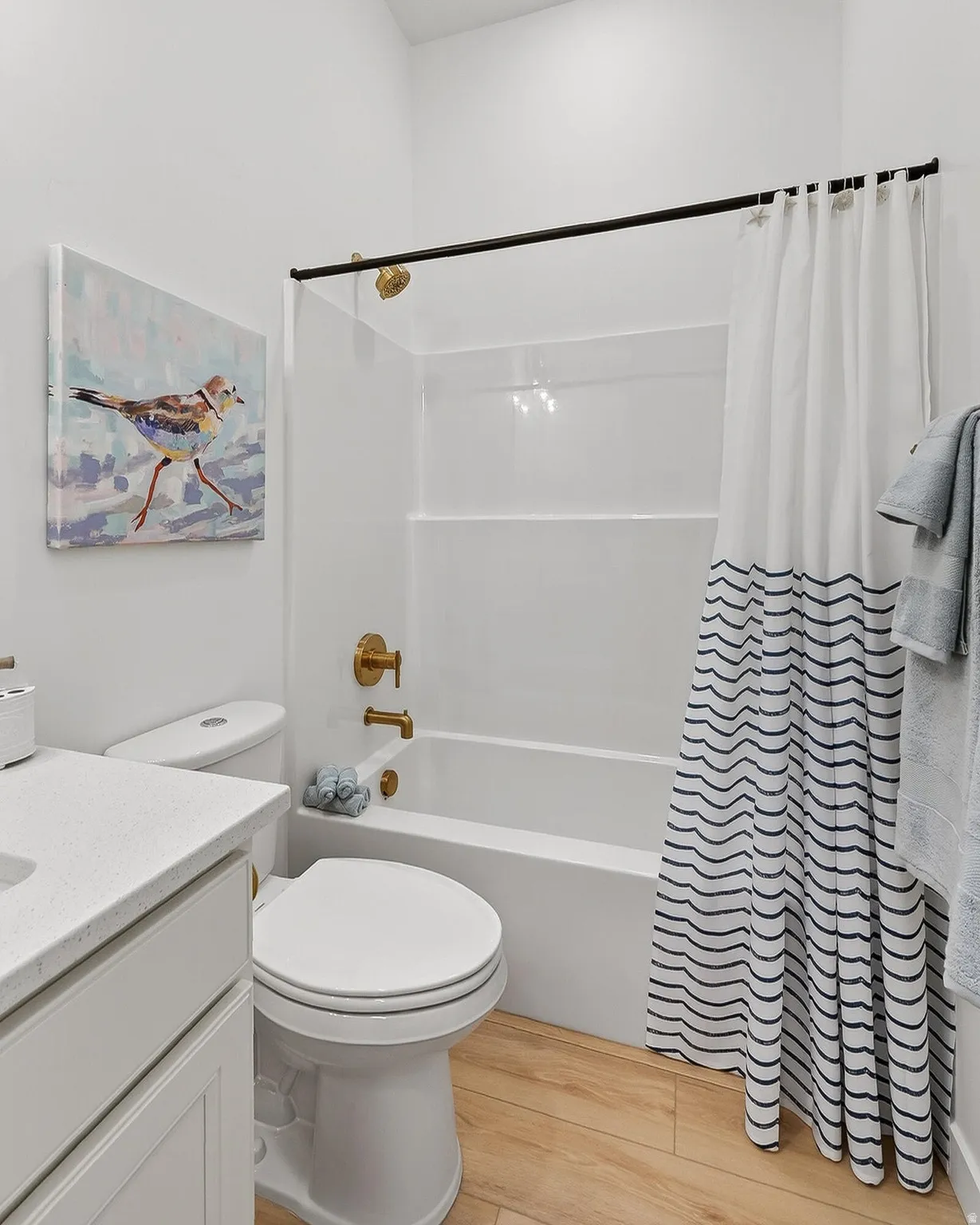 Bathroom featuring vanity, light wood-style floors, and shower / bath combo with shower curtain