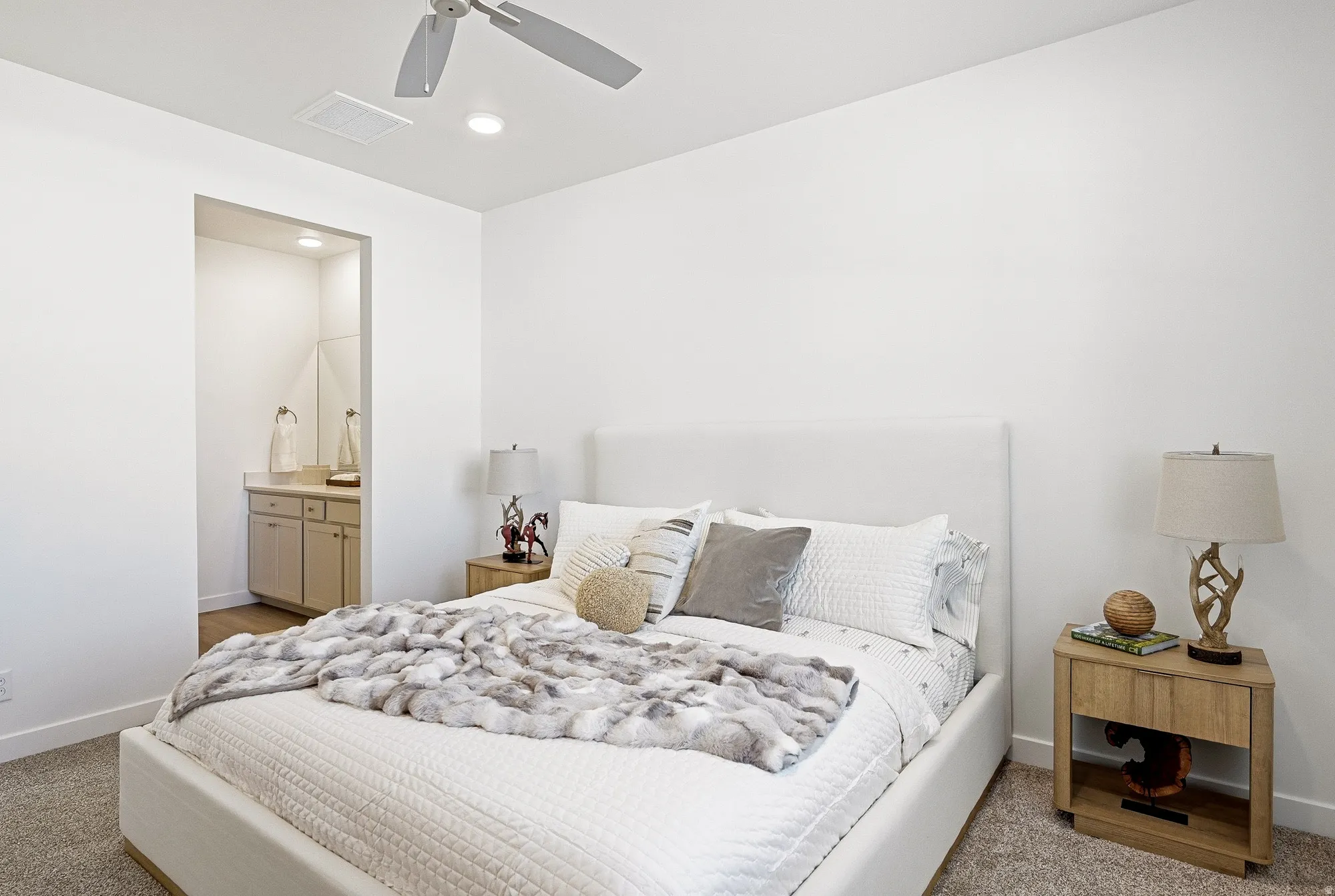 Bedroom with ensuite bath, a ceiling fan, recessed lighting, and light carpet