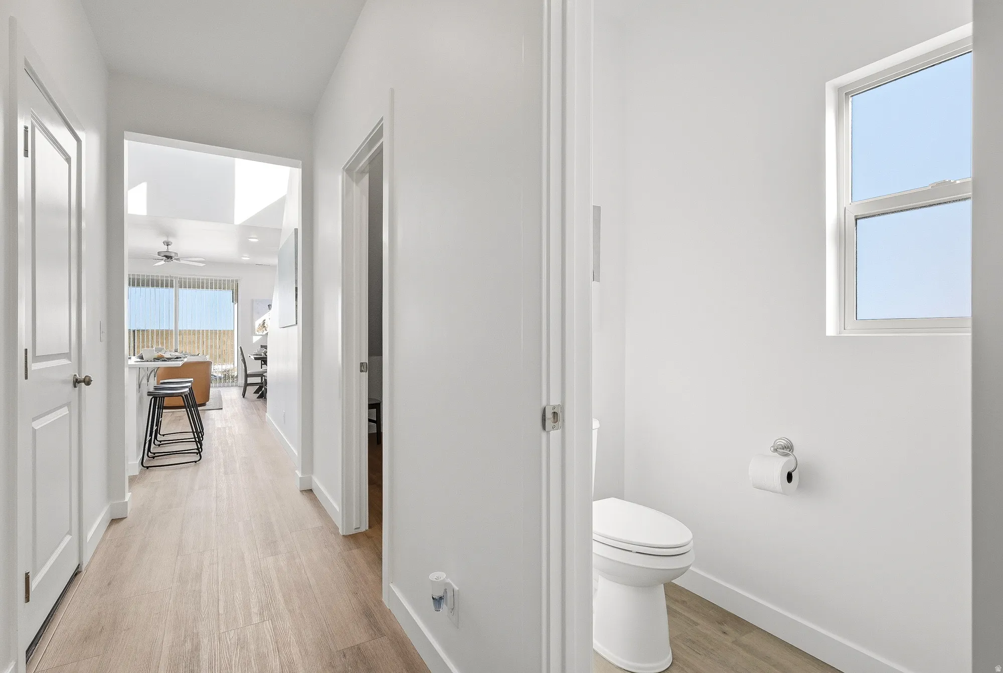 Bathroom featuring light wood-type flooring and ceiling fan