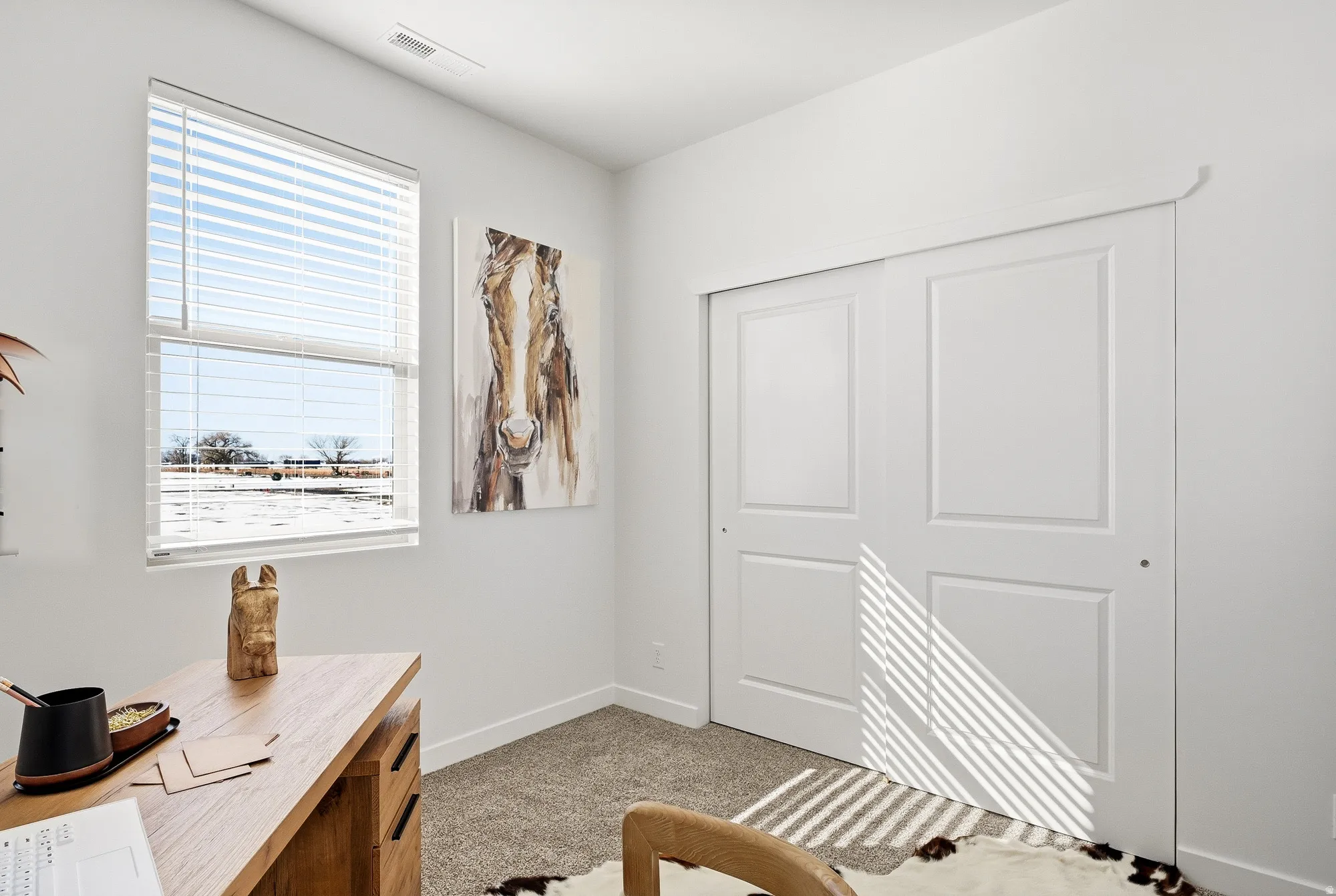 Office space with light carpet and baseboards