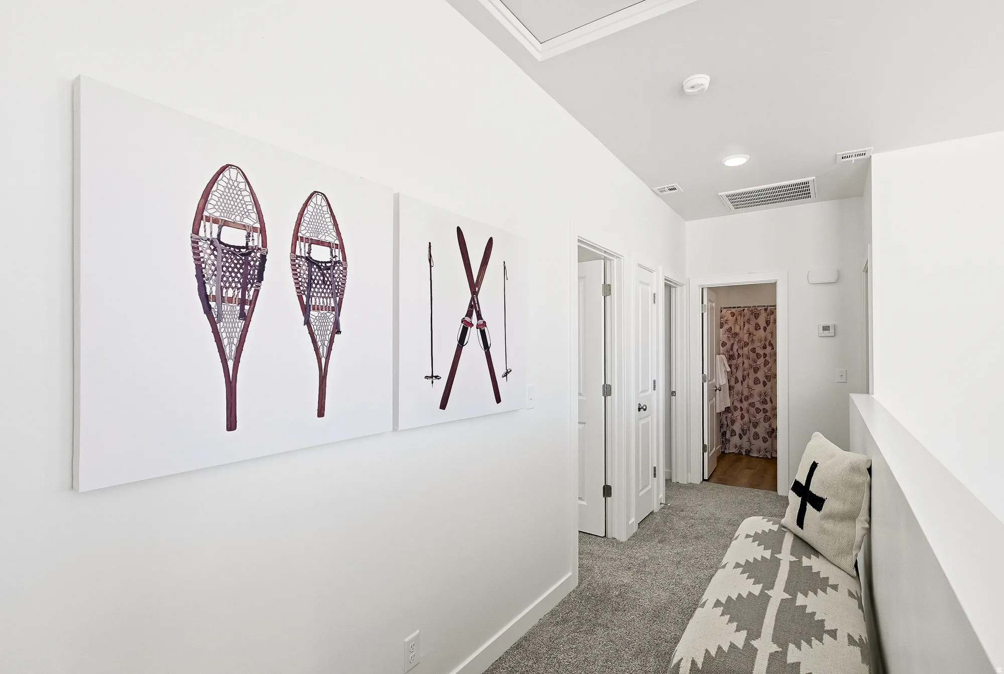 Hall featuring light colored carpet and baseboards