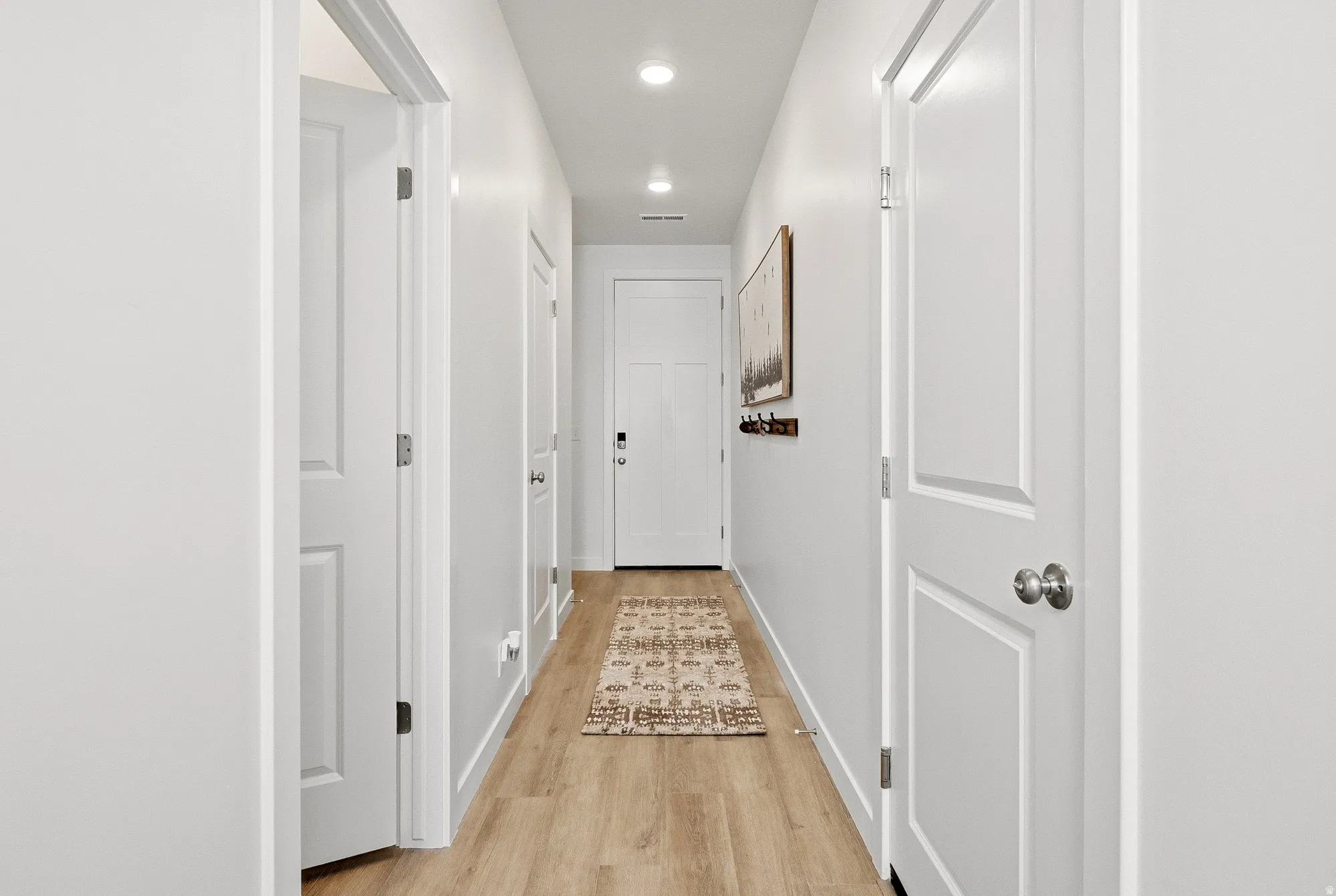 Corridor featuring light wood-style flooring and recessed lighting