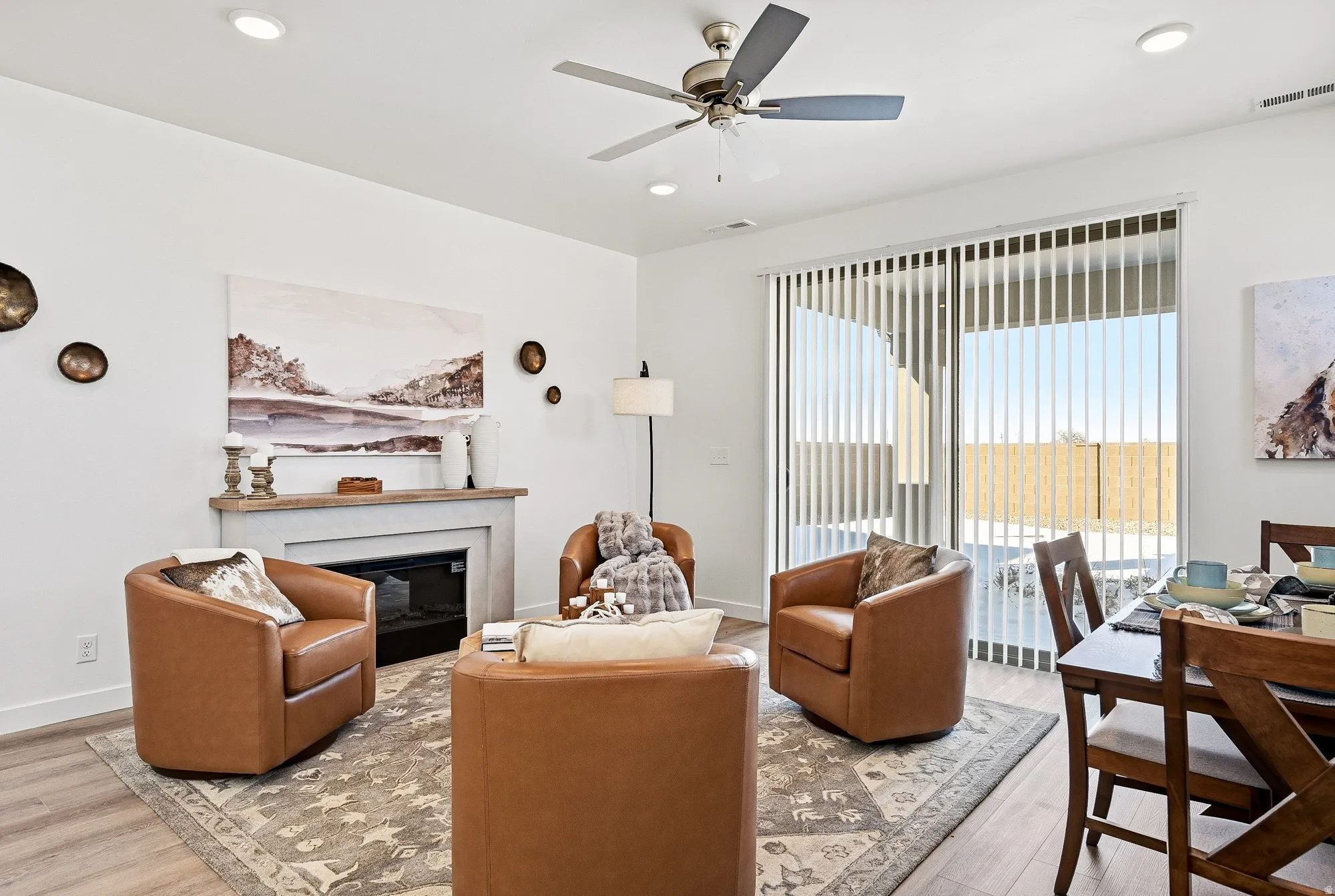 Living room with a ceiling fan, a glass covered fireplace, wood finished floors, and recessed lighting