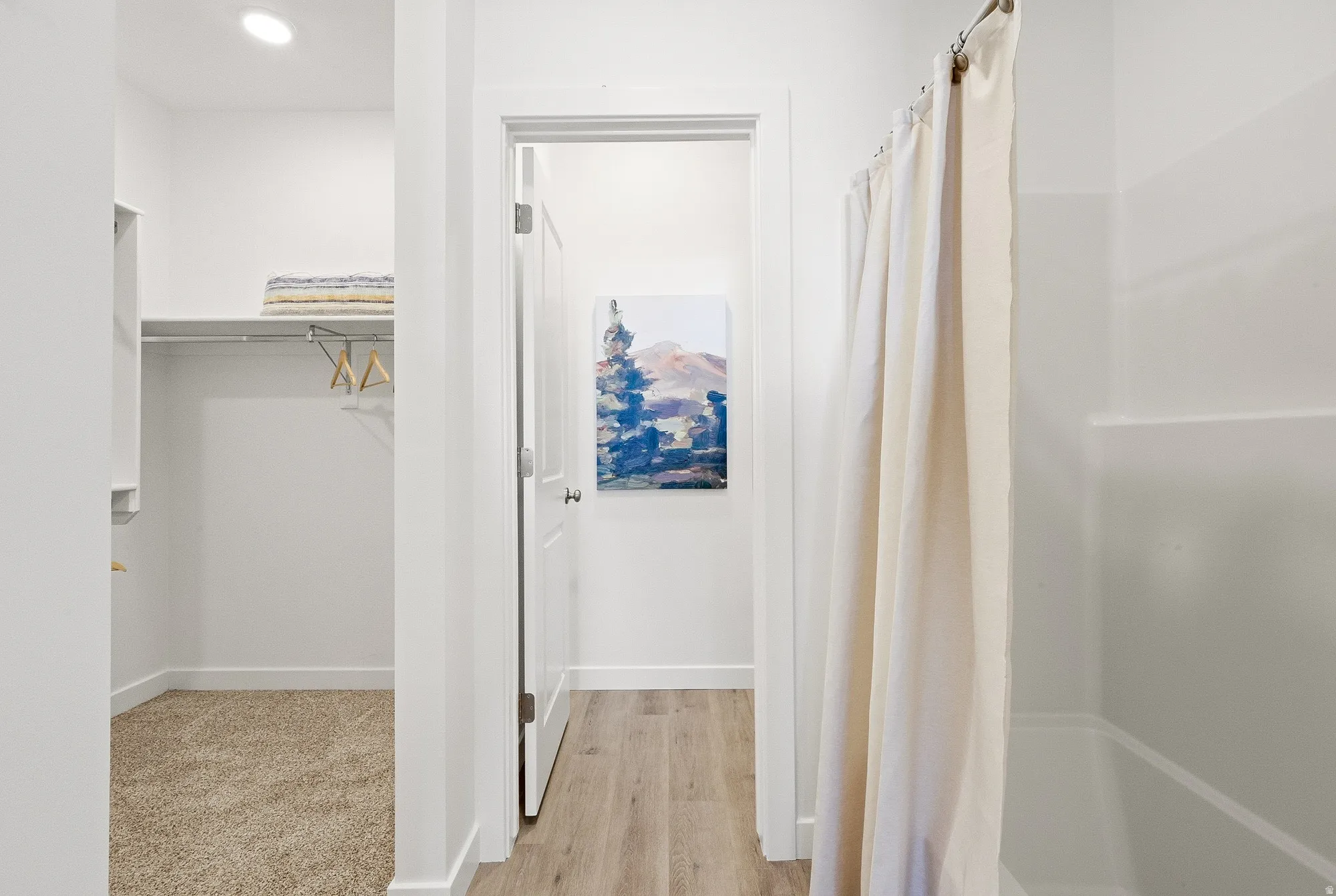 Full bathroom featuring a spacious closet, light wood finished floors, and recessed lighting