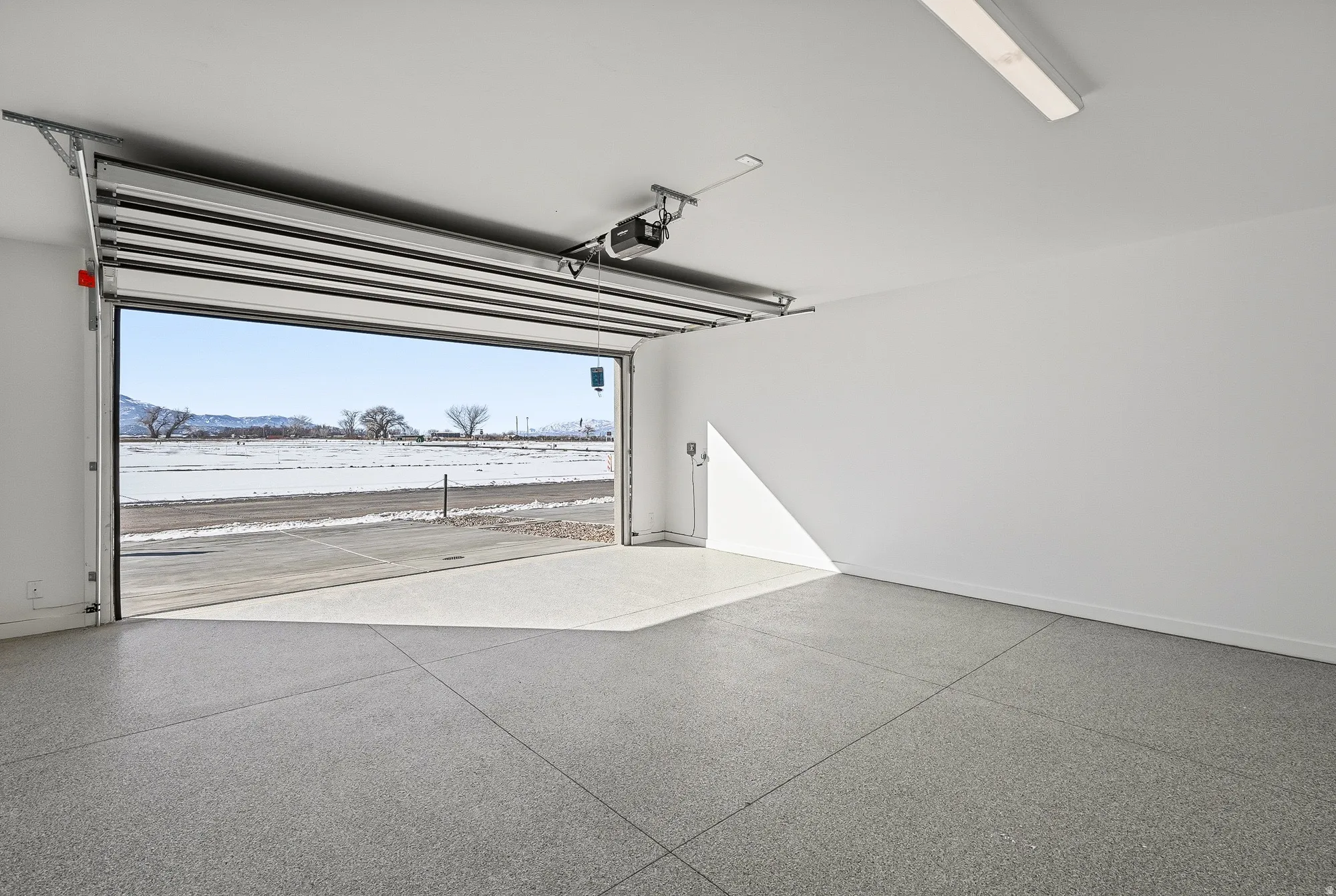 Snow covered garage with baseboards