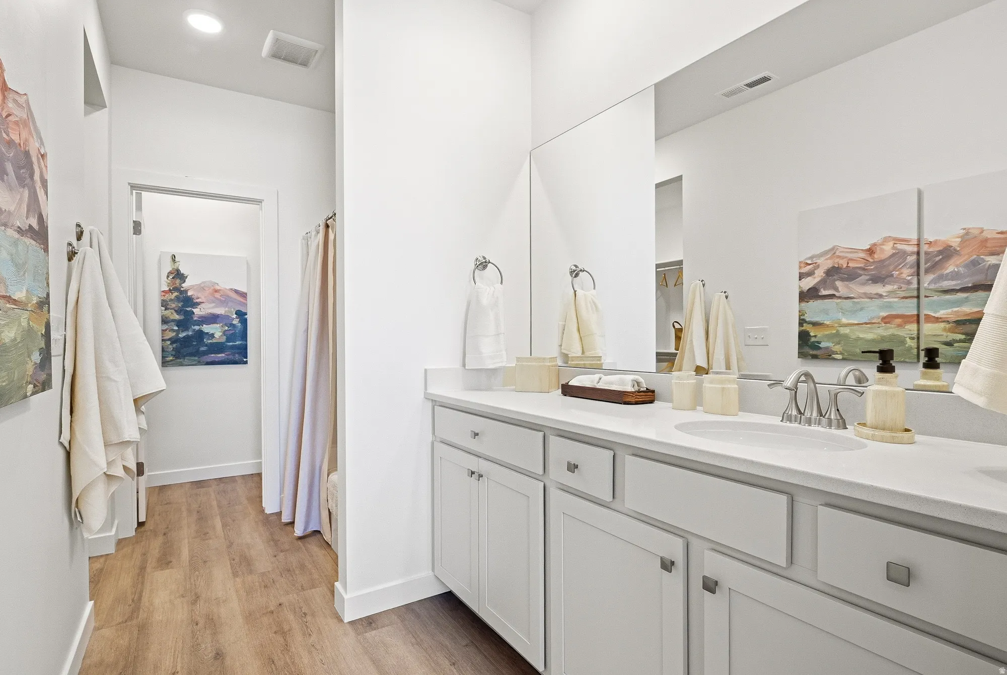 Full bath with vanity, light wood-style flooring, and recessed lighting