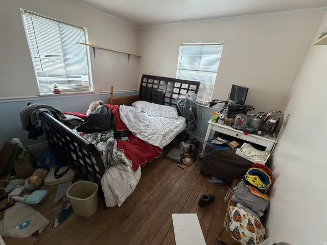 Bedroom with hardwood / wood-style floors and crown molding