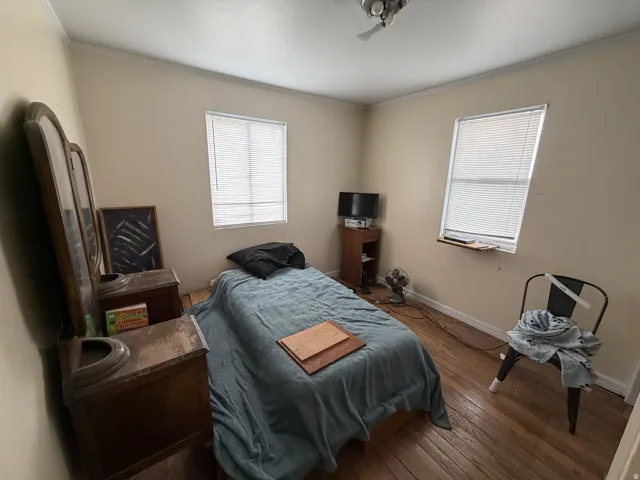 Bedroom featuring wood-type flooring and ornamental molding
