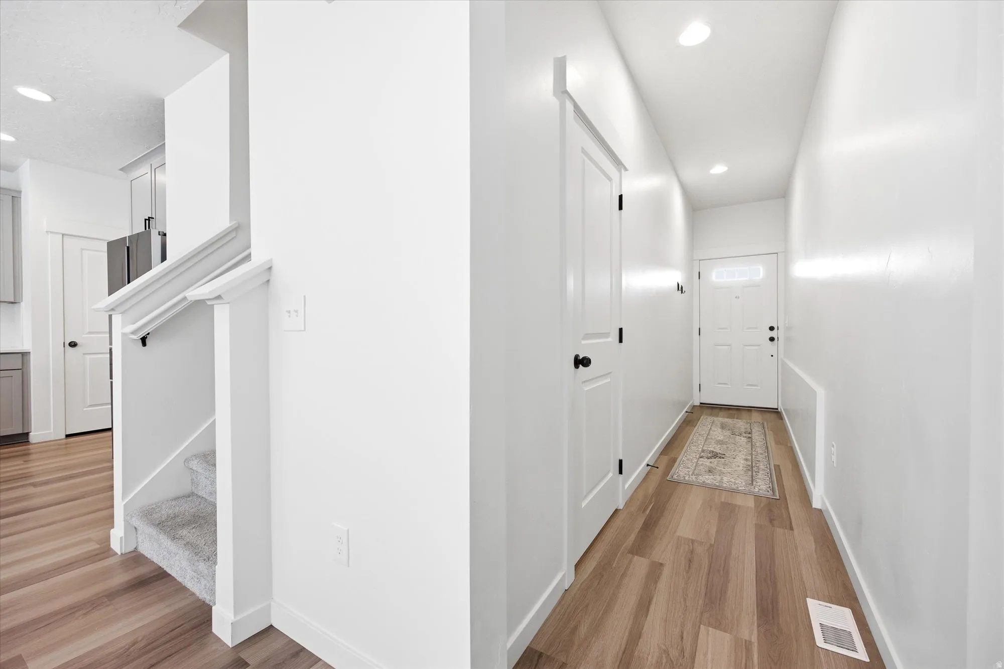 Corridor featuring light wood-style floors and recessed lighting