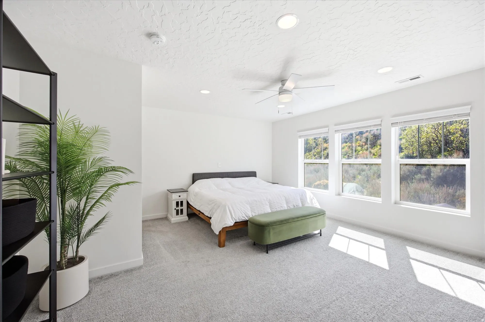 Bedroom with light colored carpet, recessed lighting, ceiling fan, and a textured ceiling