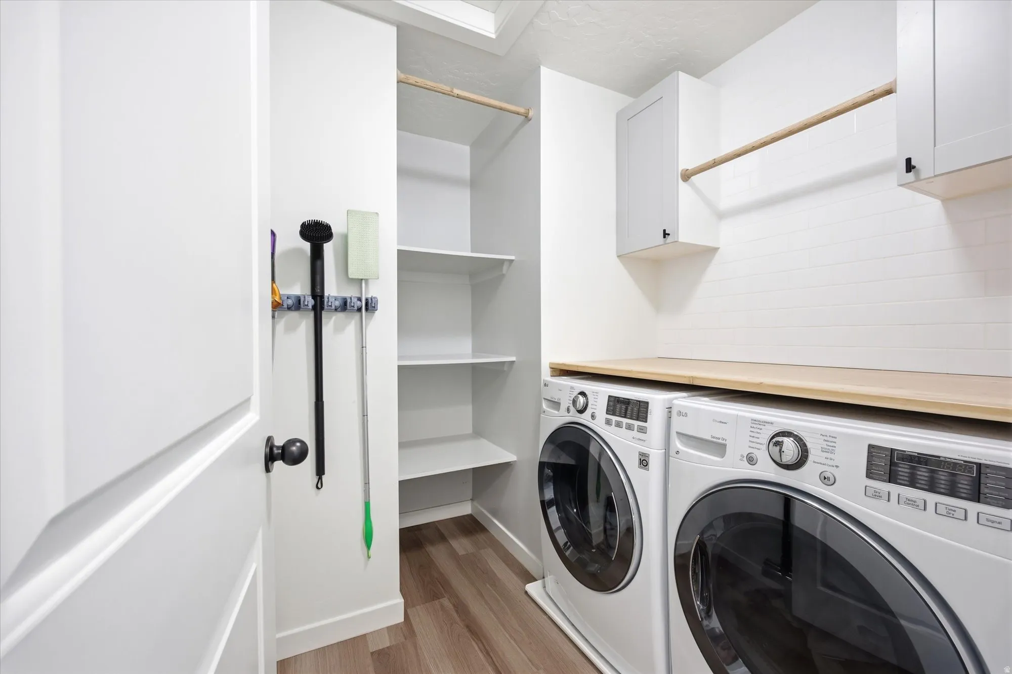 Laundry area featuring light wood-style floors, cabinet space, and washer and dryer