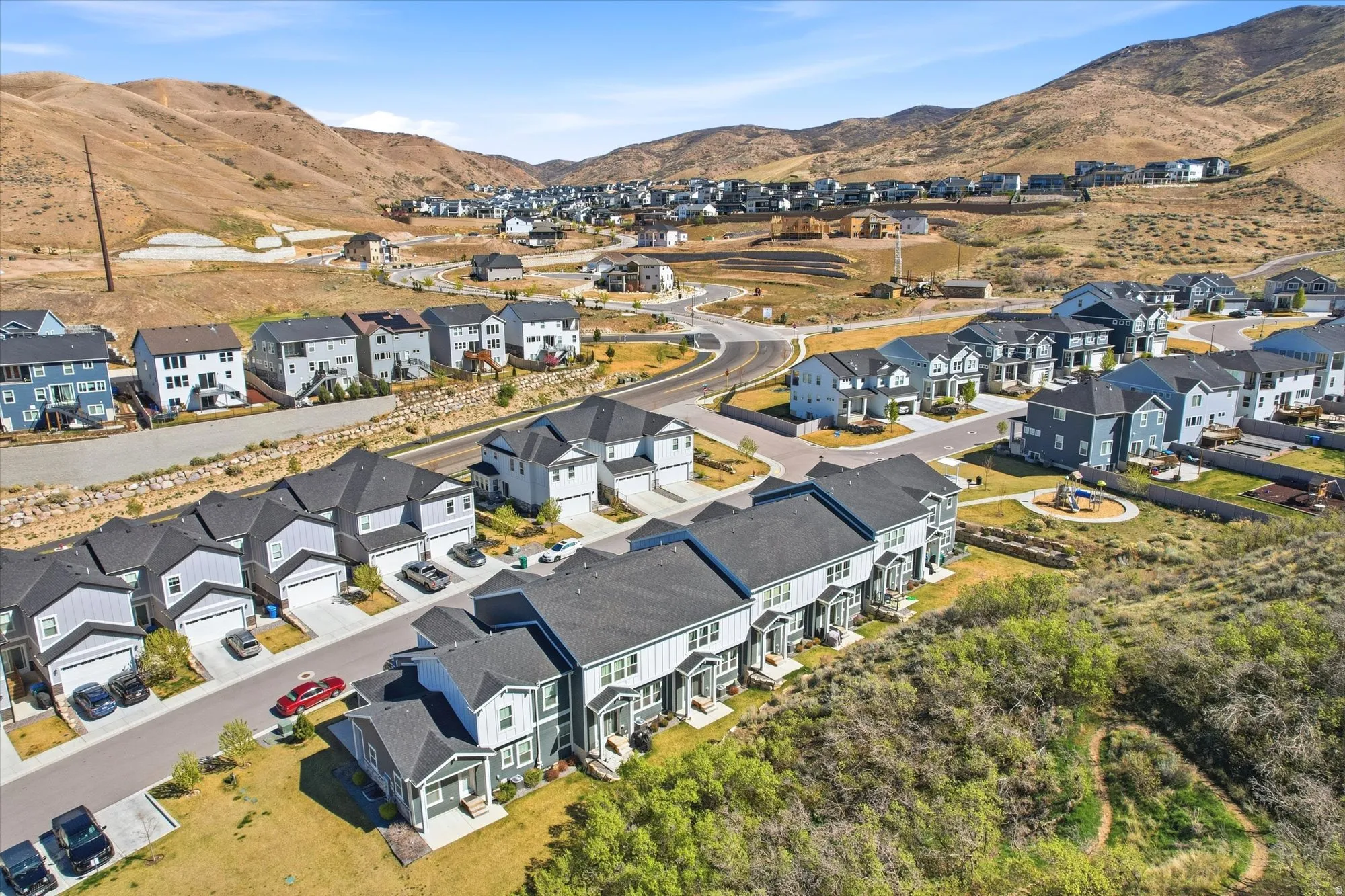 Aerial overview of property's location with nearby suburban area and a mountainous background