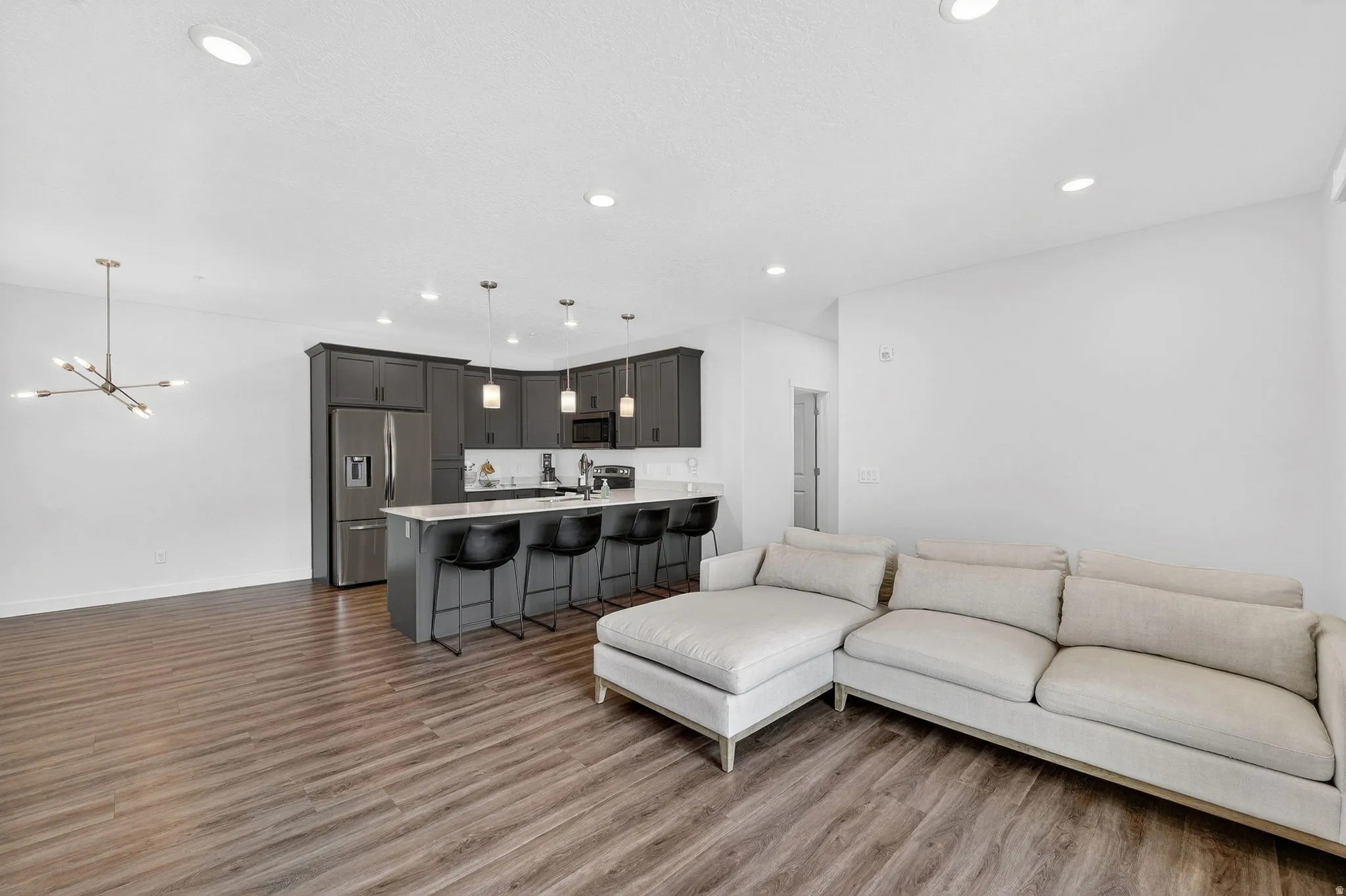 Living room featuring dark wood-type flooring and hanging lights