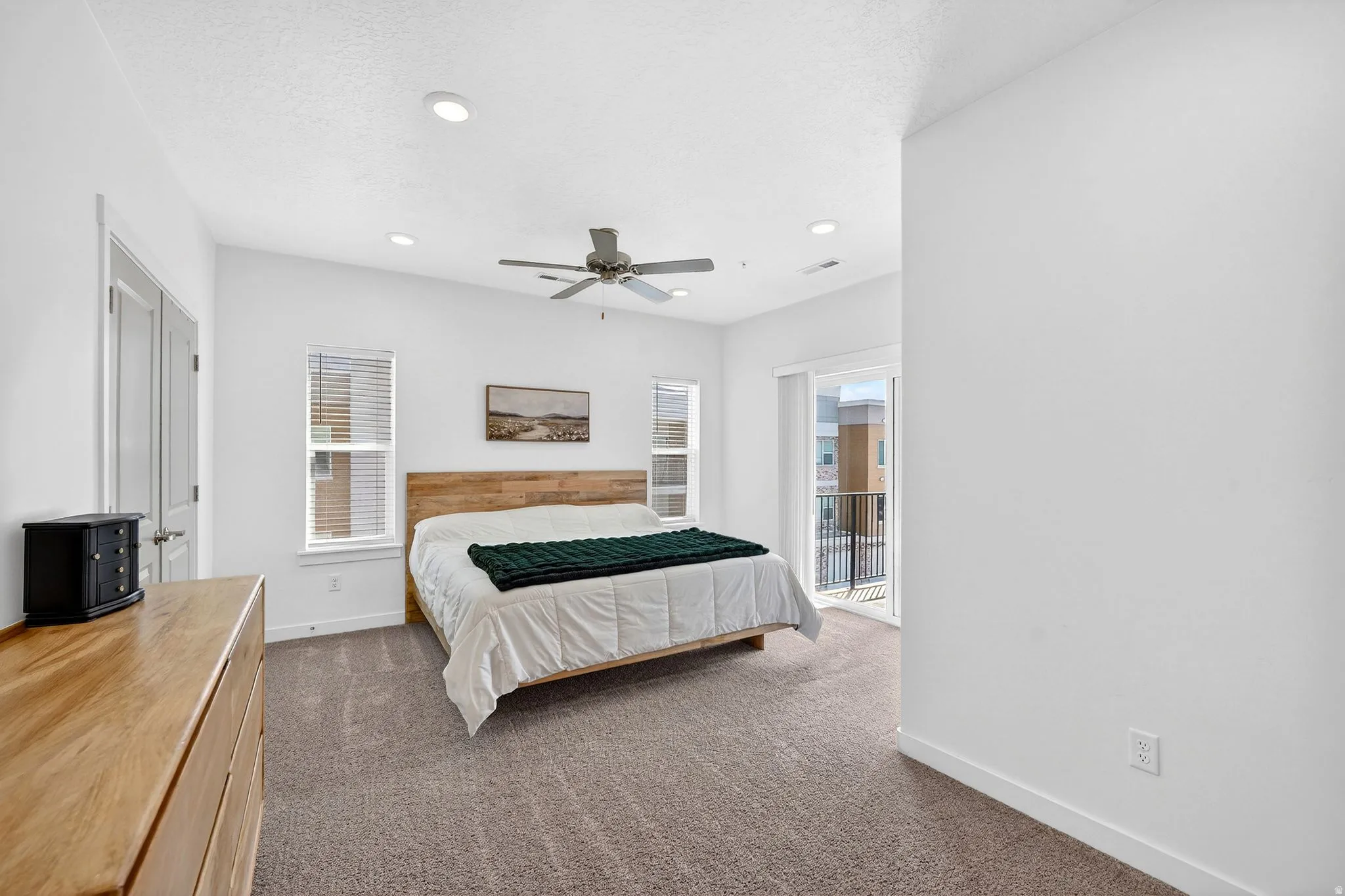 Bedroom with access to exterior, dark colored carpet, multiple windows, recessed lighting, and a ceiling fan