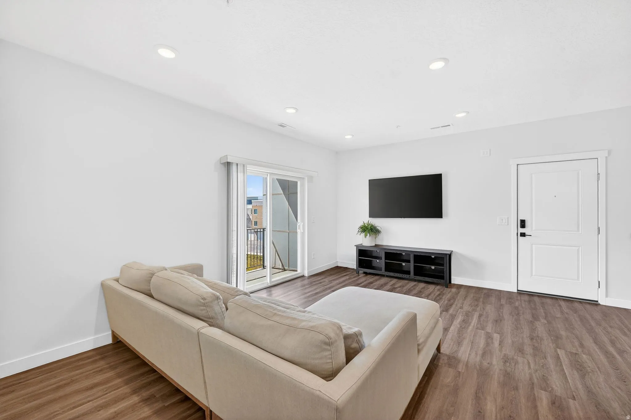 Living area featuring dark wood-type flooring and recessed lighting