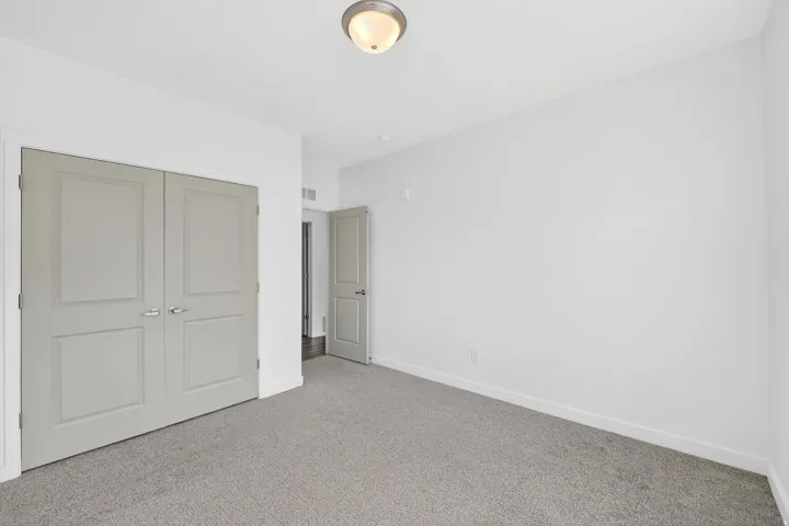 Unfurnished bedroom featuring carpet flooring and a closet