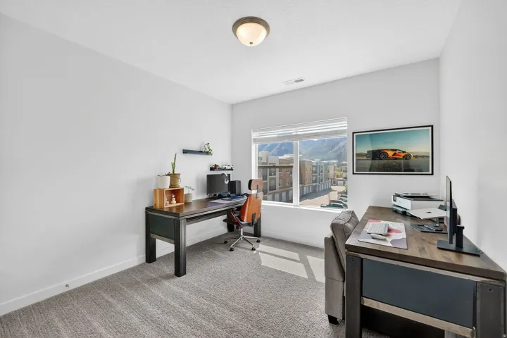 Home office featuring light colored carpet and baseboards