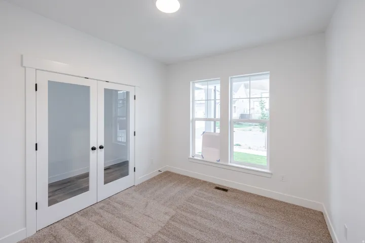 Room featuring neutral carpeting, white walls, and a contemporary ceiling light fixture