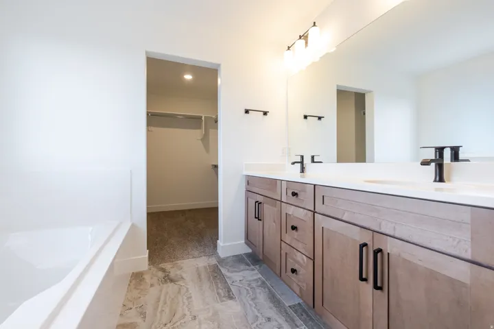 Dual vanity with white countertops and undermount sinks, set against a large wall-mounted mirror