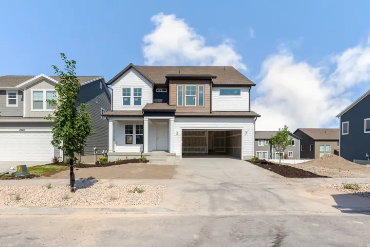 Contemporary two-story residence featuring white siding and dark trim accents